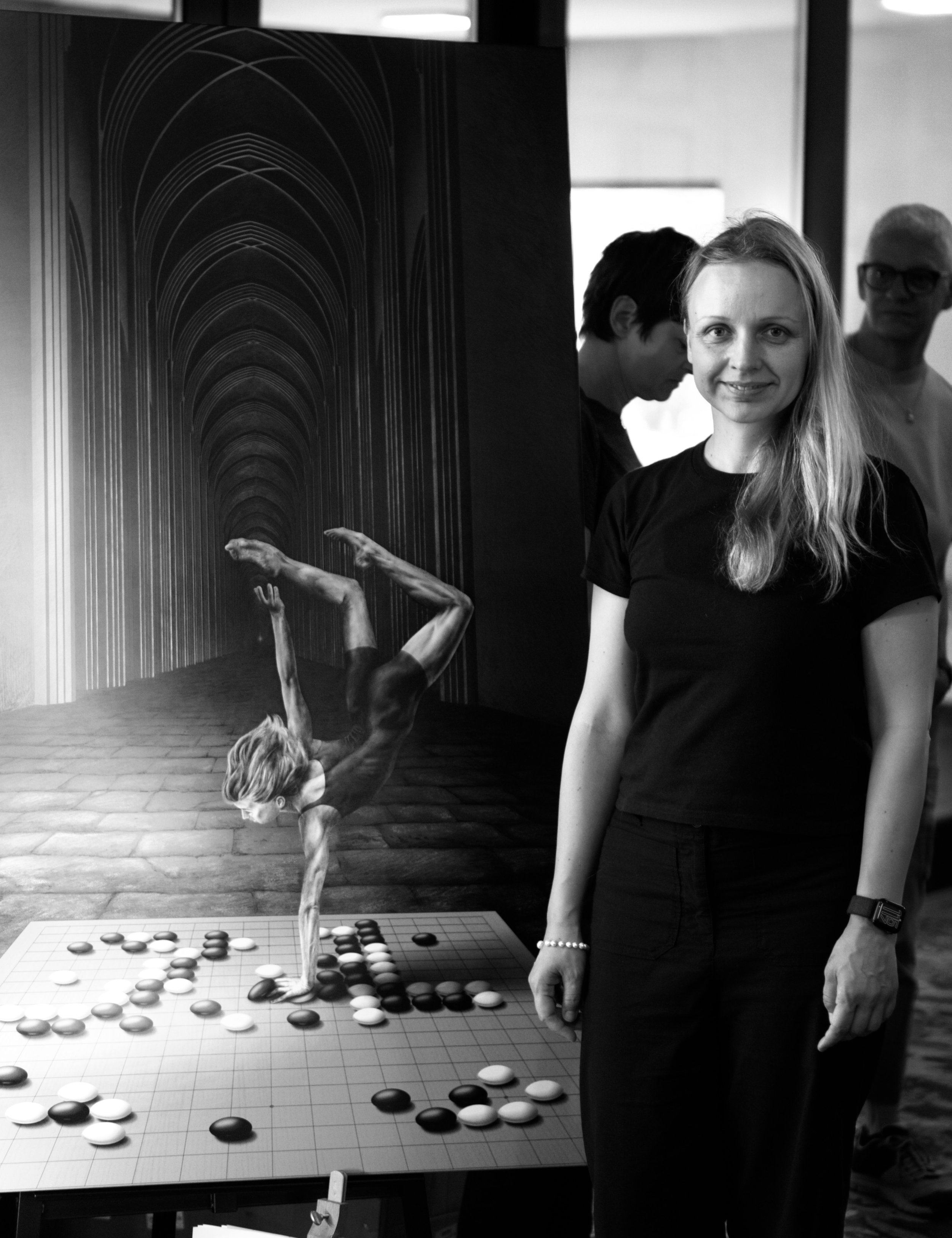 Anna Vital beside a reproduction of her painting titled Move 78.