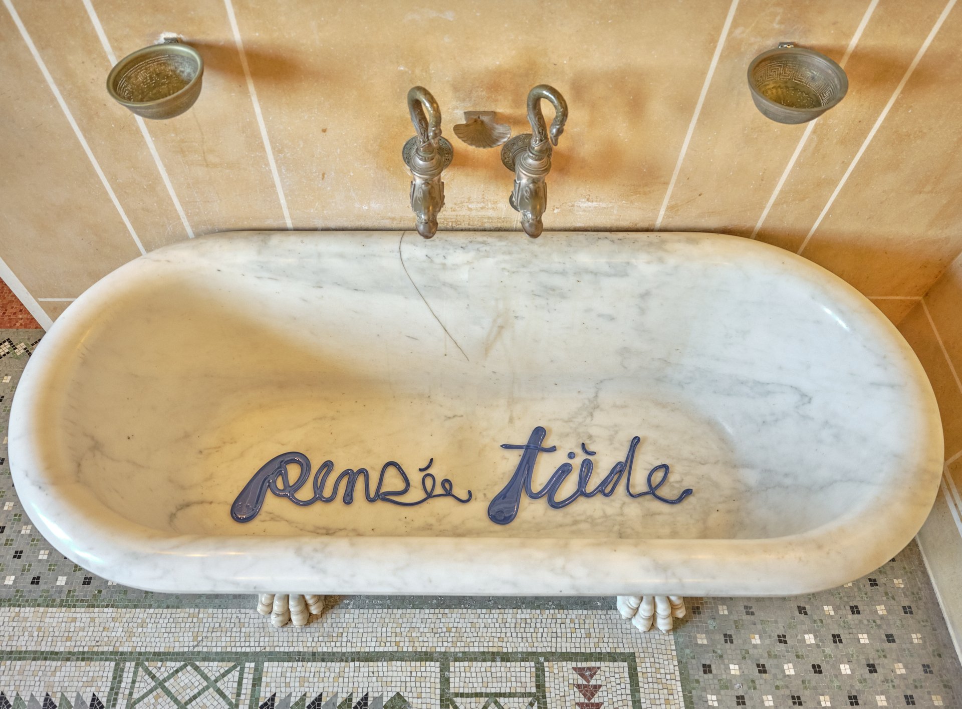Le verre de la Pensée Tiède a coulé dans une baignoire en marbre de Carrare .Dans cette mise en scène, l’œuvre glisse ironiquement vers l’évacuation de la baignoire comme s’effaceraient les âmes tièdes dans le théâtre de la vie.