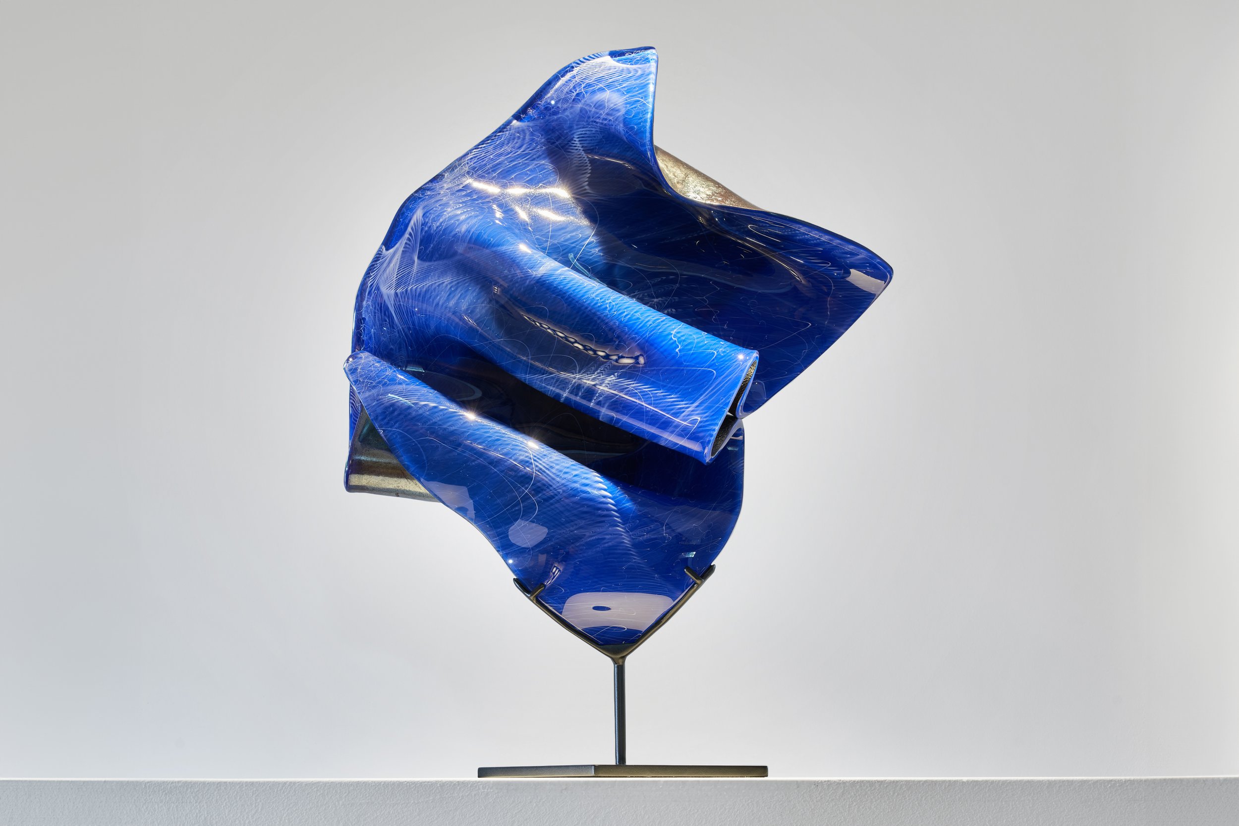 « J’ai été saisi par les vagues roulantes, le miroitement de l’eau et je me suis mis à couper, couper le bleu par la bande et insuffler au verre ces mouvements, cette mémoire symbolique. » Antoine Pierini