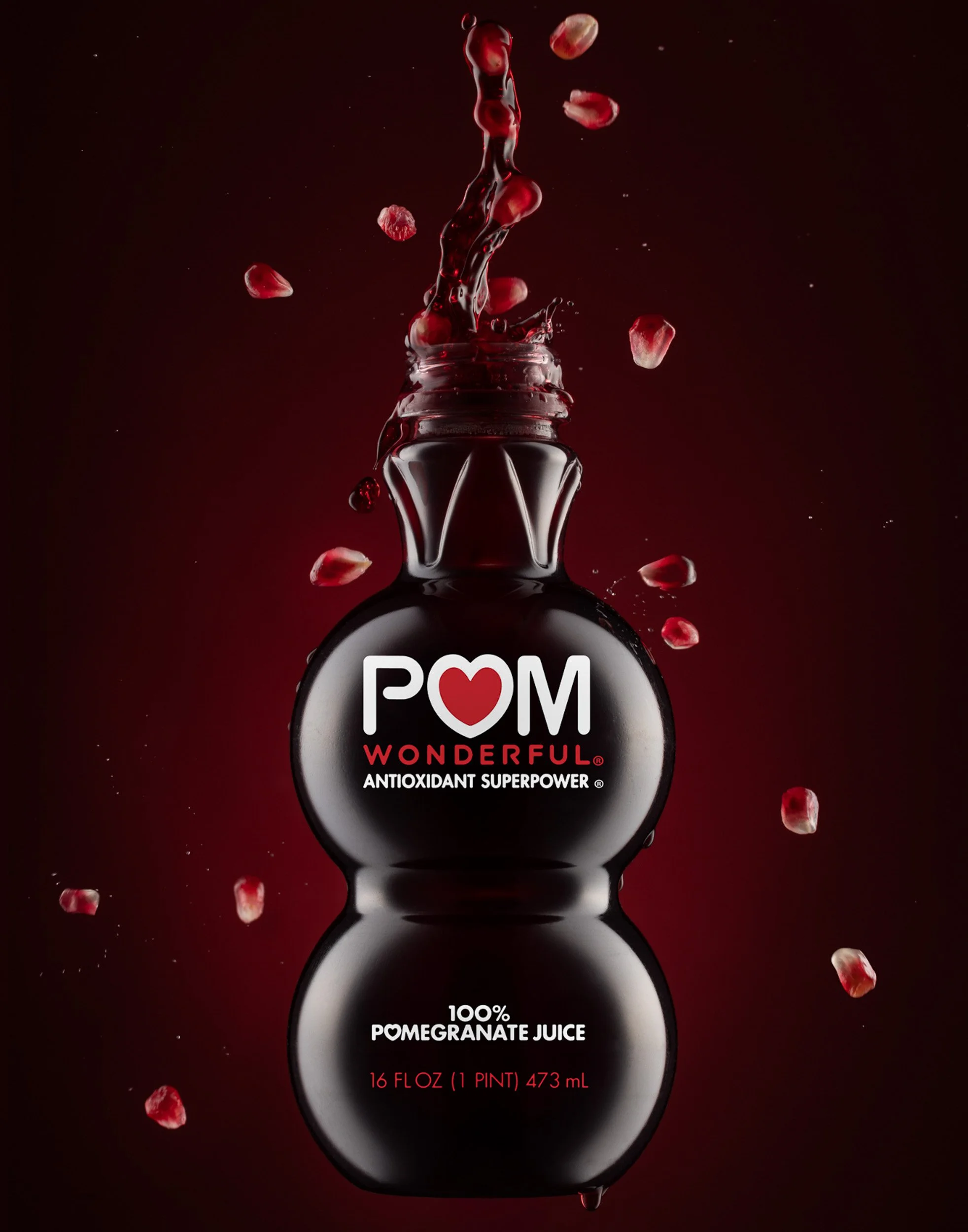 High-speed liquid splash photography, POM pomegranate juice beverage advertising, commercial drink styling, professional product motion photography, vibrant fruit juice branding imagery.