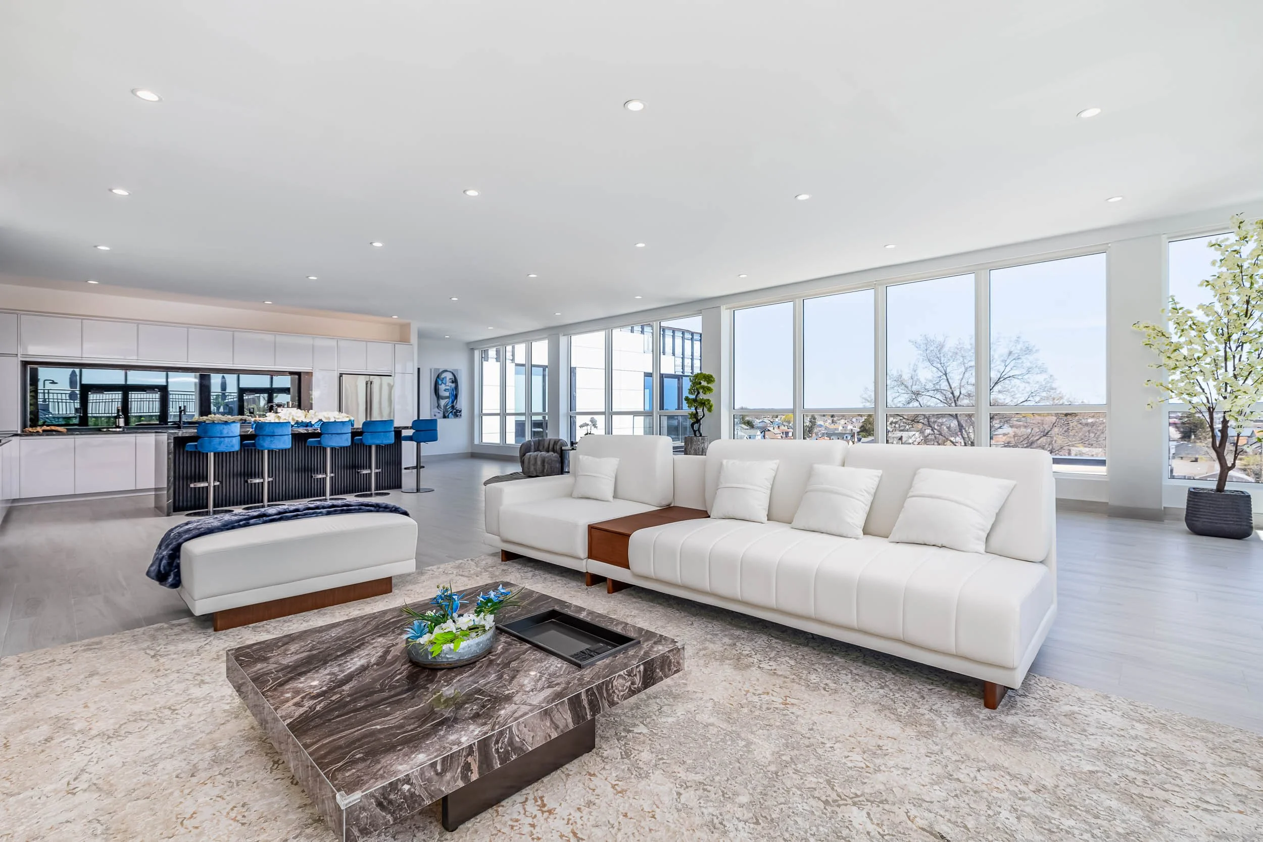 Professional interior design photography for luxury lounges, wide-angle architectural shot of a modern open-concept living area, high-end commercial interior with floor-to-ceiling windows, modern furniture staging for hospitality branding, architectu