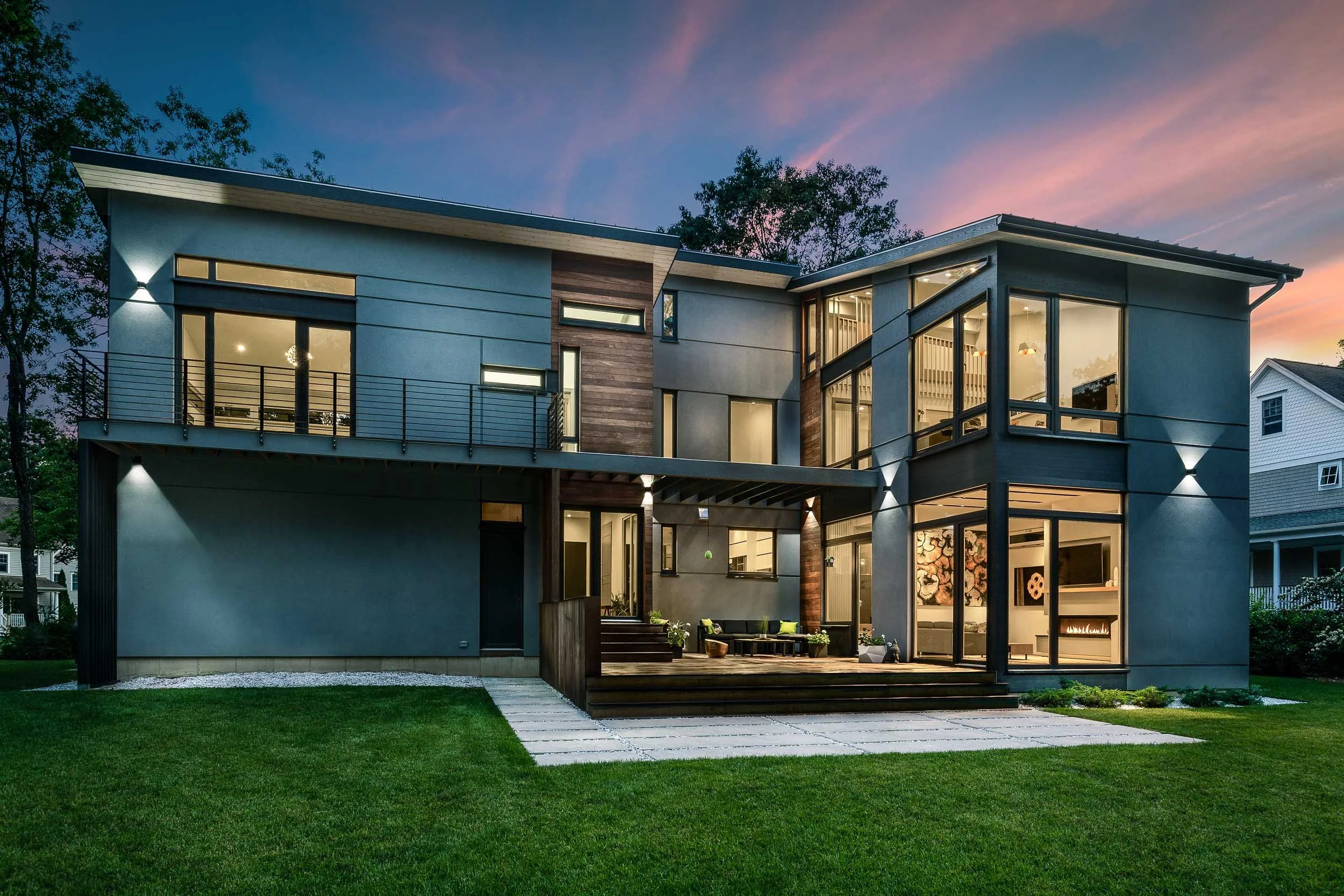 Modern residential architecture photography, luxury home exterior at dusk, professional twilight photography, geometric building design with ambient outdoor lighting, high-end facade photography with sunset sky.