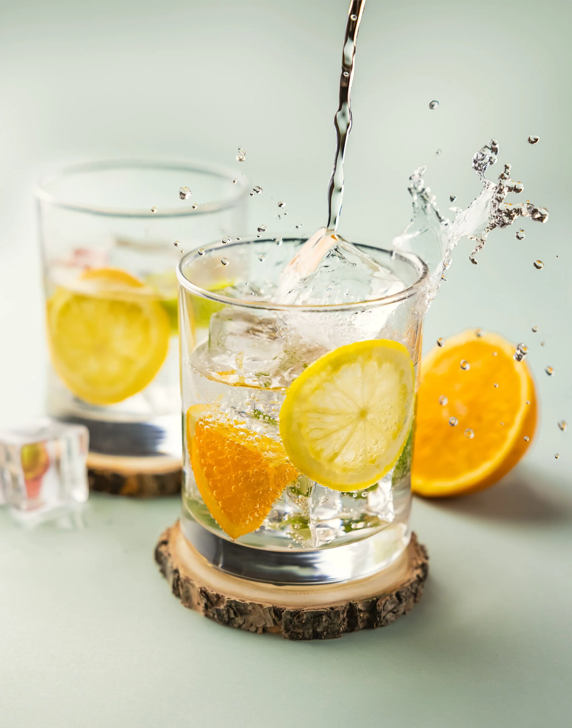 High-speed beverage splash photography, professional gin and tonic pour shot, commercial vodka soda advertising imagery, citrus cocktail motion photography, refreshing spirits branding for beverage marketing.