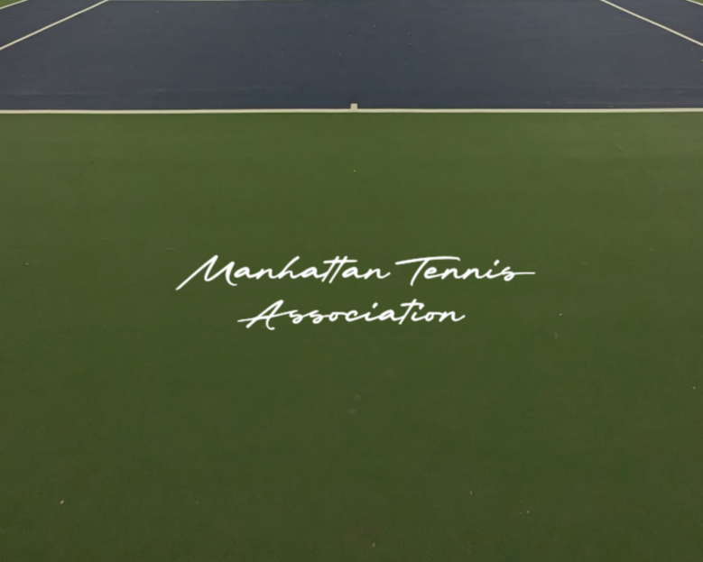 Indoor tennis court with a green curtain wall, net in the middle, and reflective polished floor showing the curtain and ceiling.