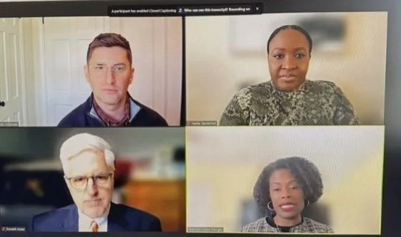 Screenshot of a virtual video conference with four participants, two men and two women, each in separate frames.