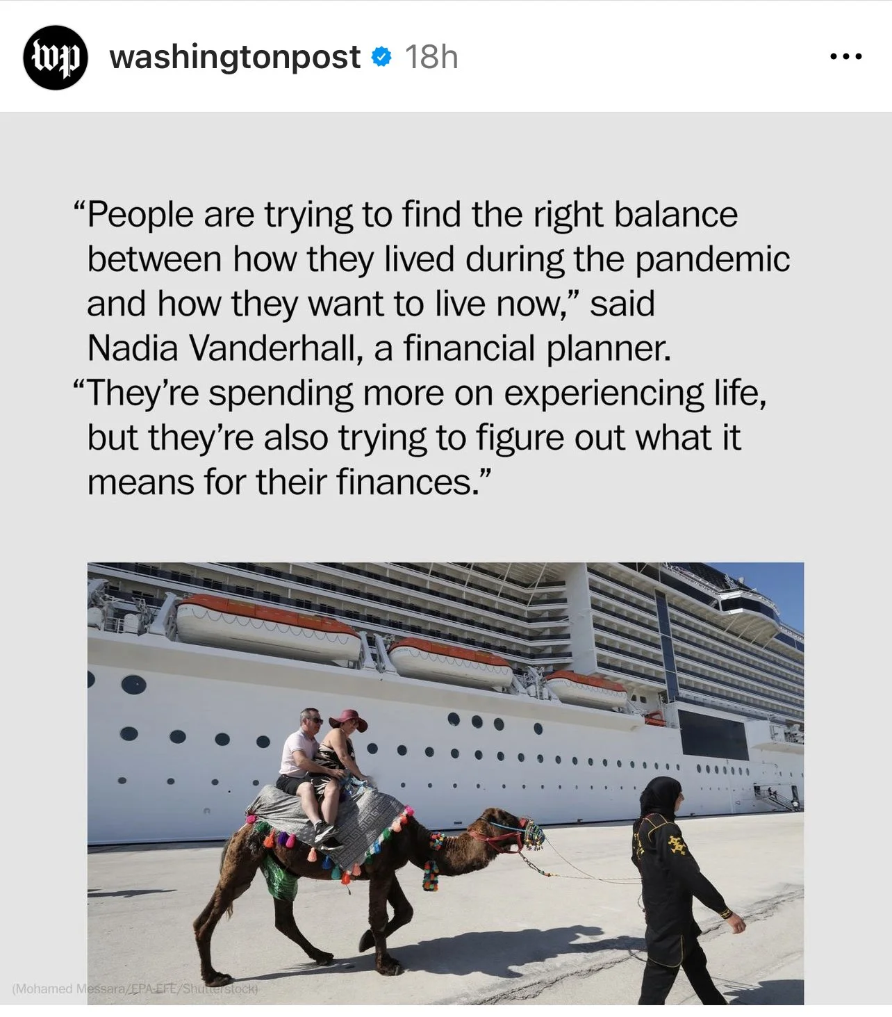 People riding a decorated camel in front of a large cruise ship, with a staff member leading the camel, on a sunny day.