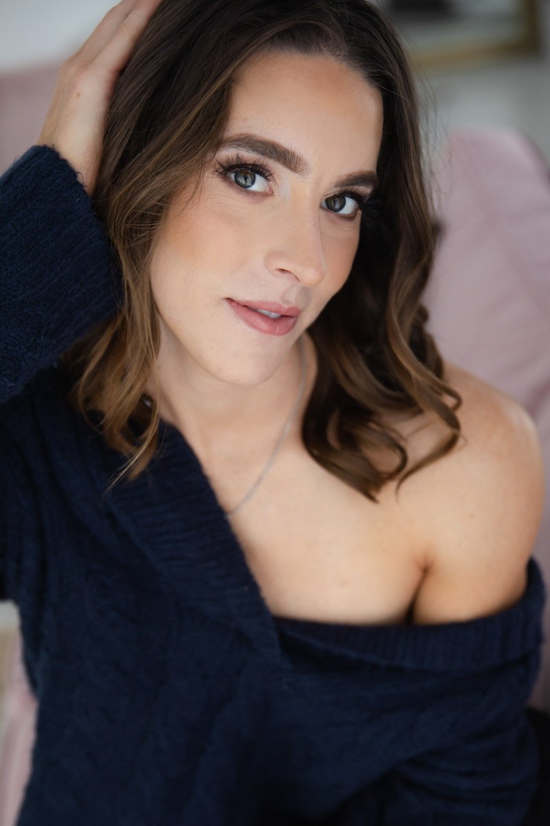  Boudoir portrait of brunette woman wearing loosely  fitting sweater 