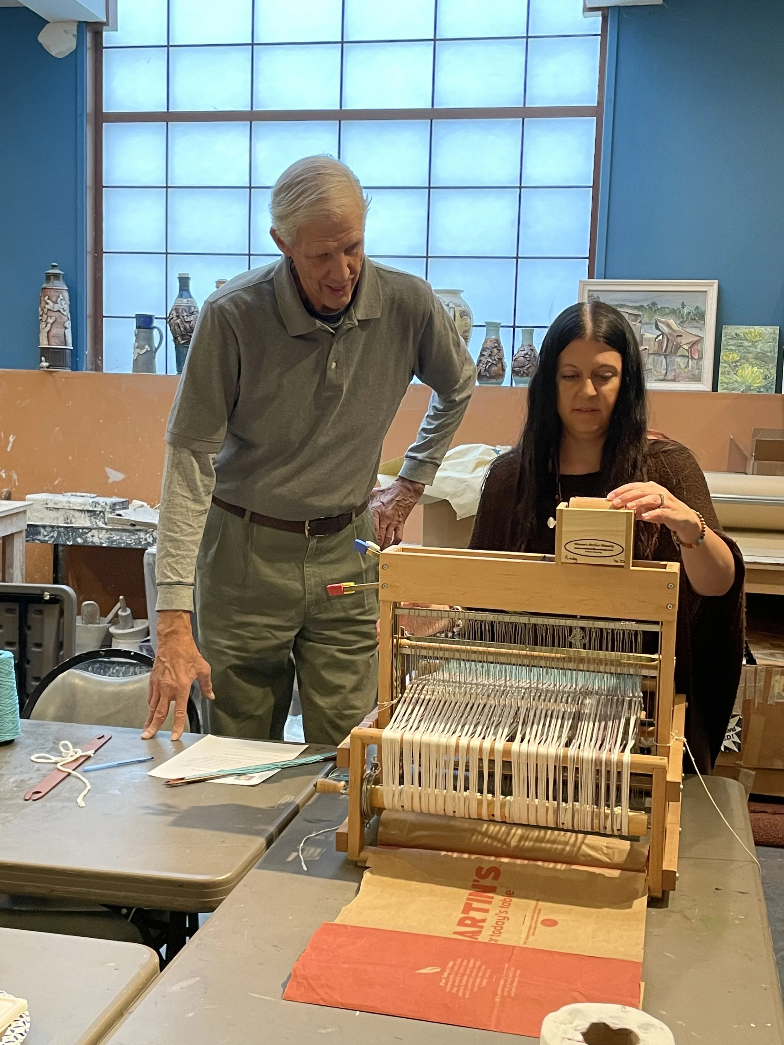 Inventor works with a new weaver learning to  weave with the tool to track every pick