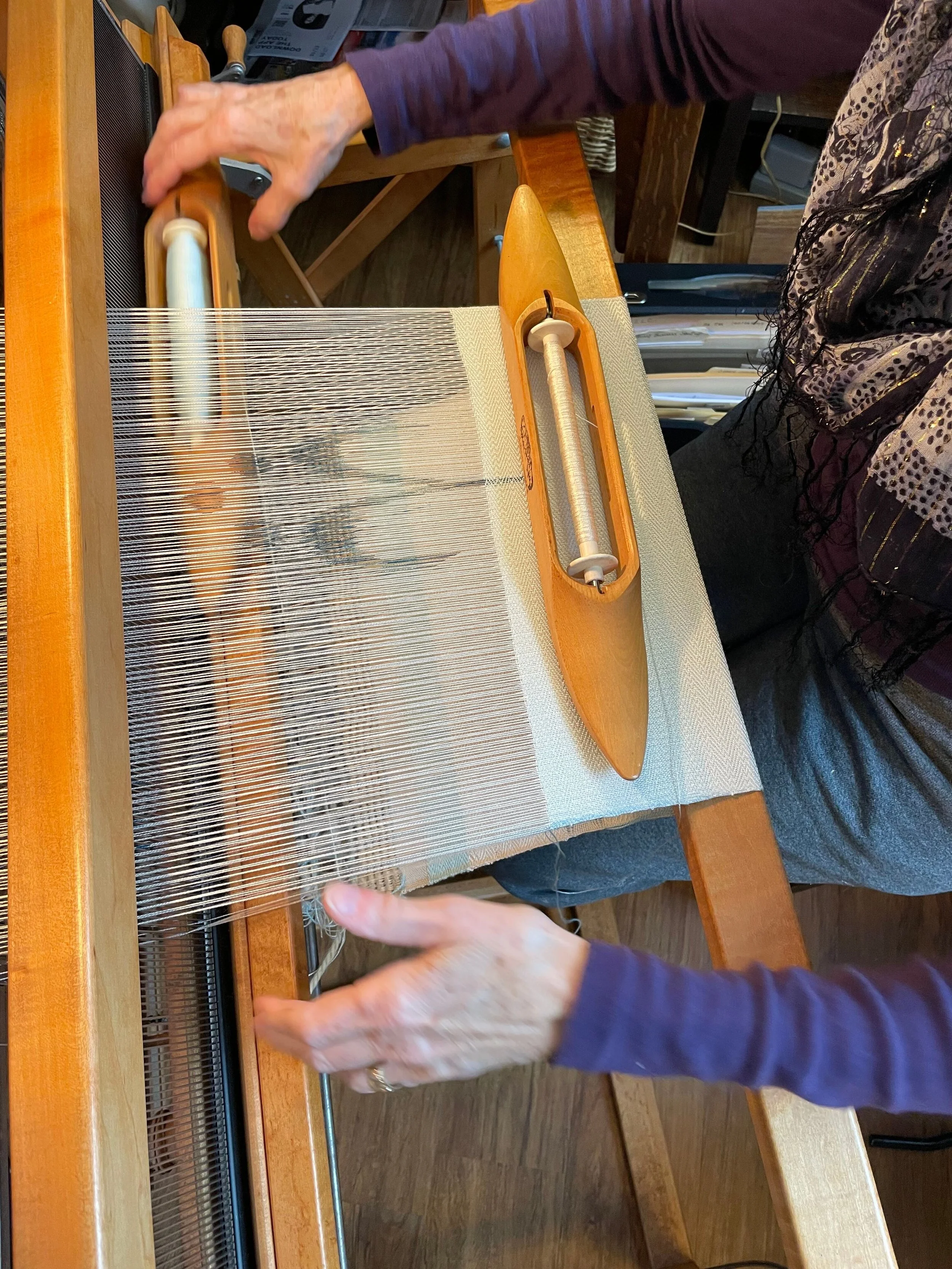 hands with weaving shuttles