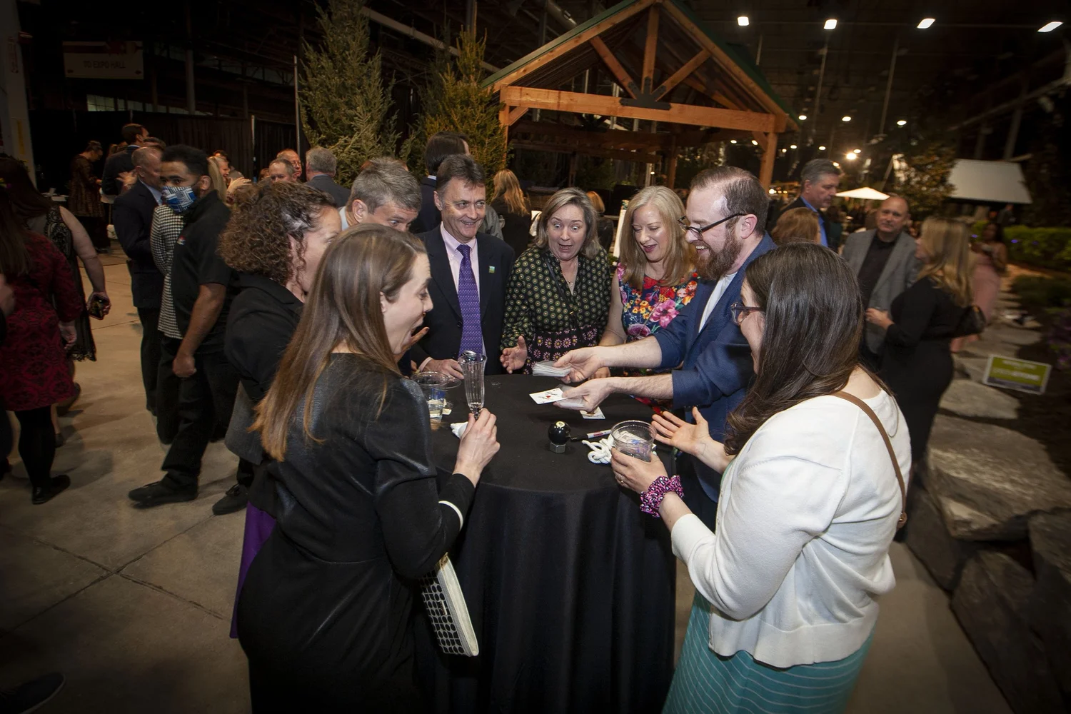 Guests crowded around a cocktail table watching close-up magic