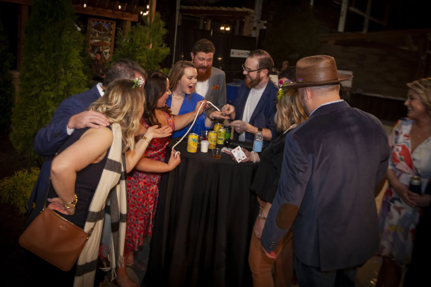 A small group watching a close-up routine at a party