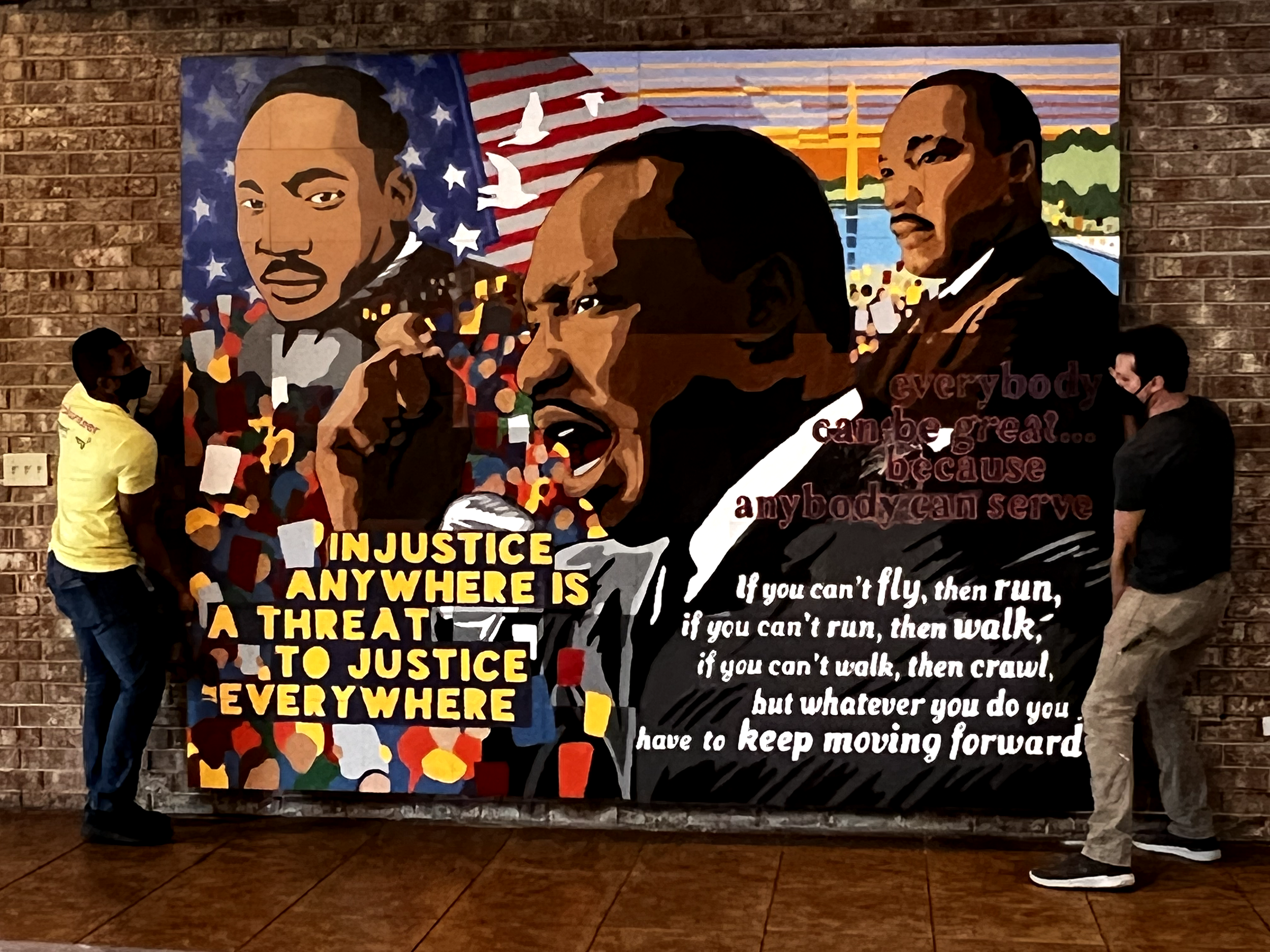 volunteers hang up MLK mural.