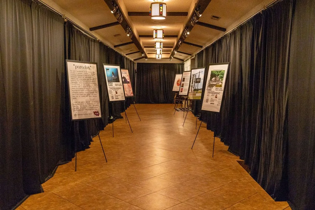 Hallway art exhibit with posters on easels