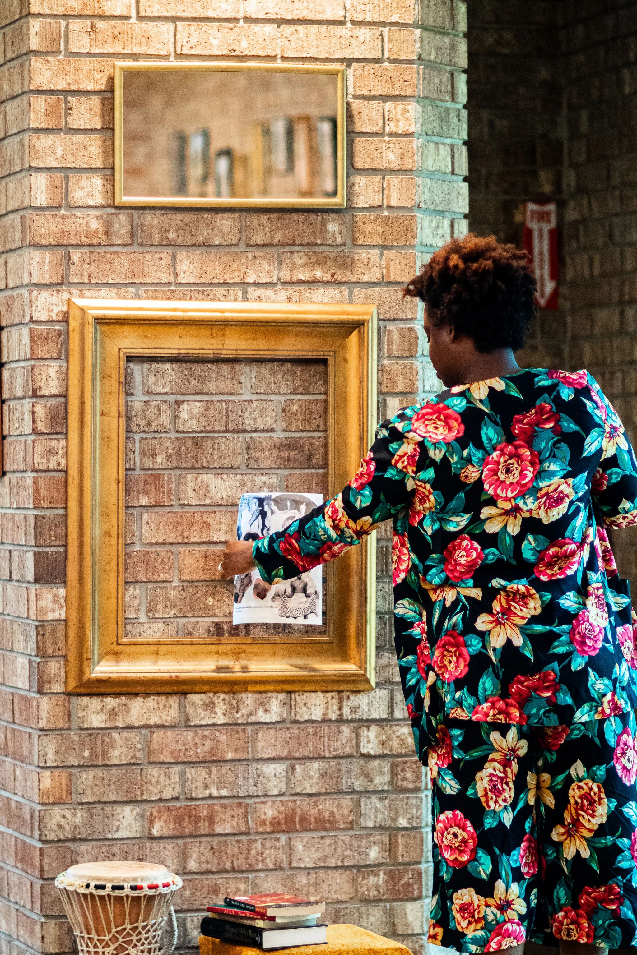 Artistic Director Stacy Allen framing collage made by students.  