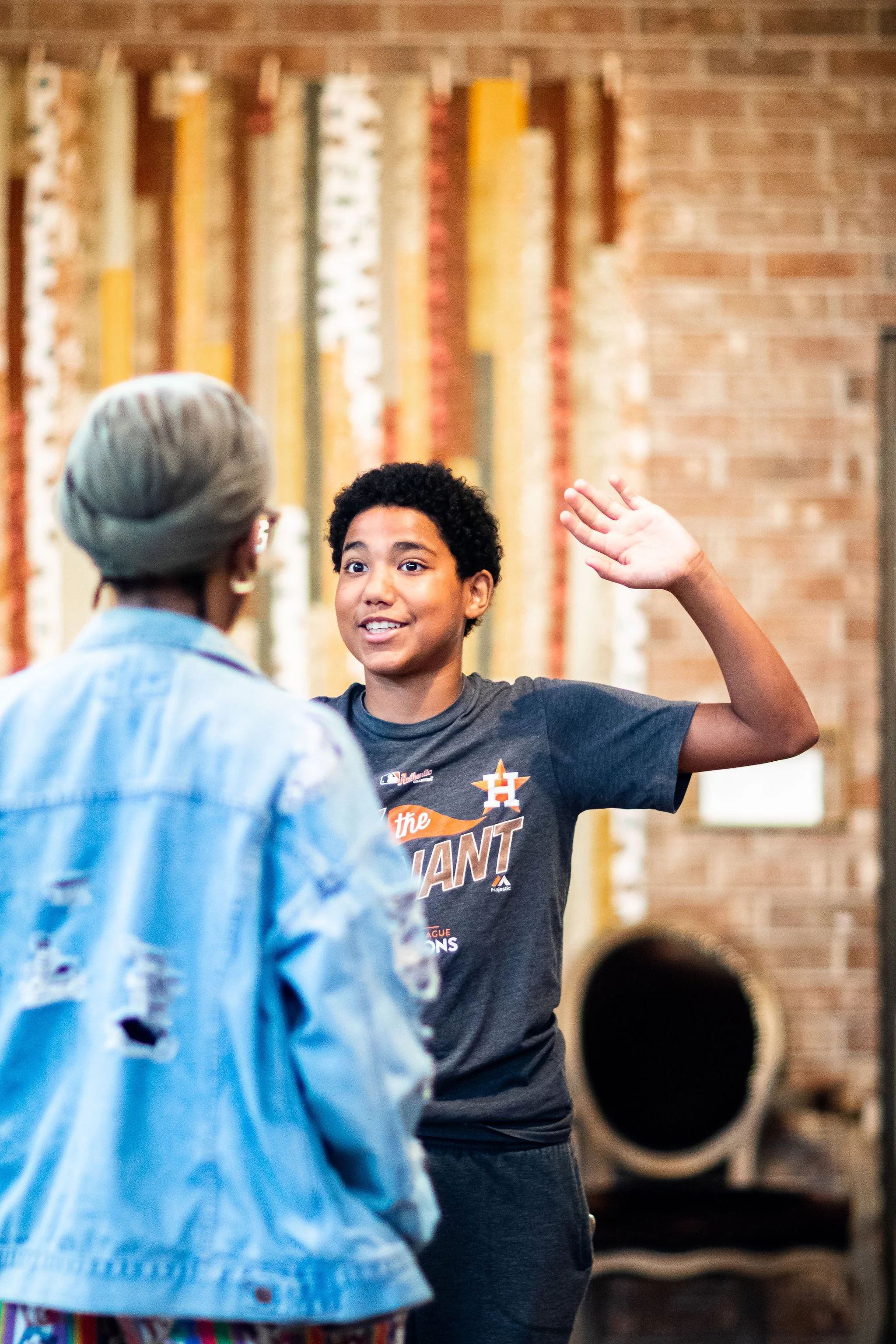 Boy raising his hand for his teacher.