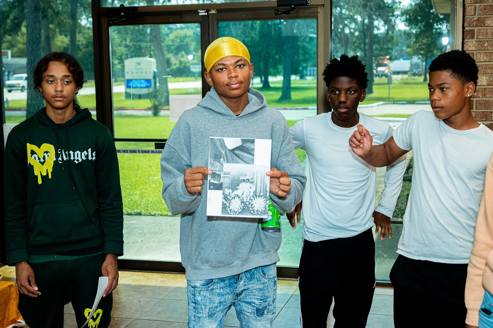 Young boy showing art collage that was created during Aesthetic Inherences tour.
