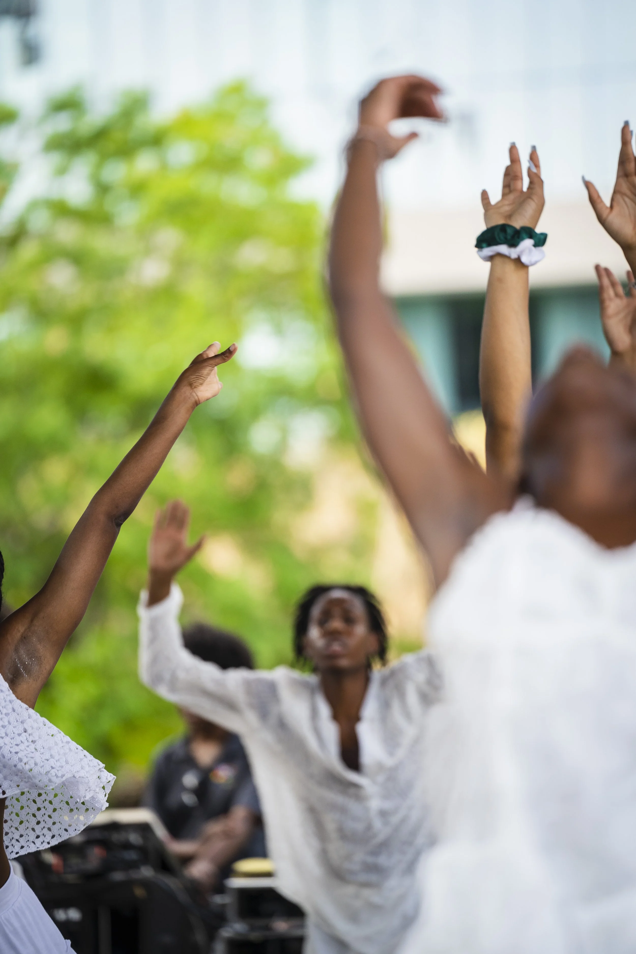 Dancers perform with their hands gracefully  moving through the air. 