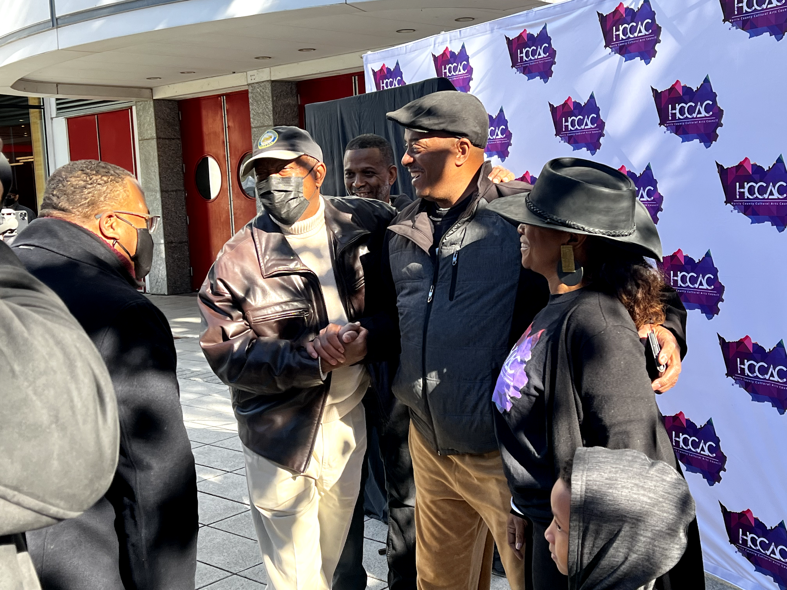 Mayor Turner, Ted Ellios, and Michelle Bonton take a picture in front of the Harris County Cultural Arts banner.