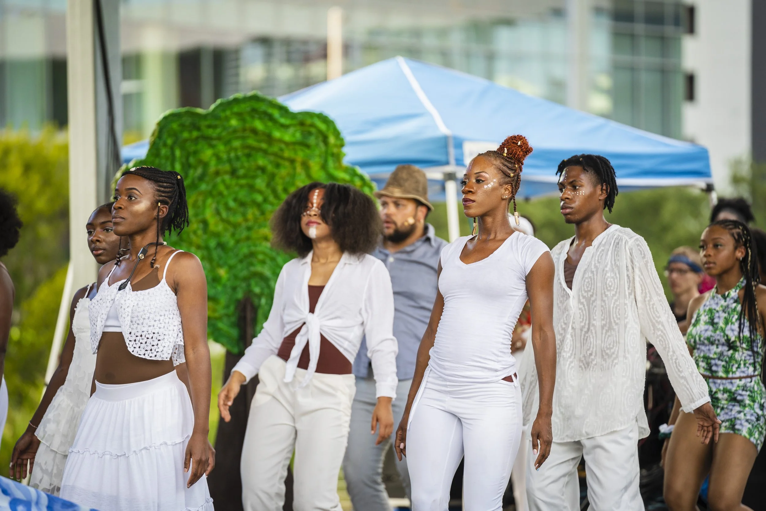 Group of dancers dressing in all white standing in synchronization. 