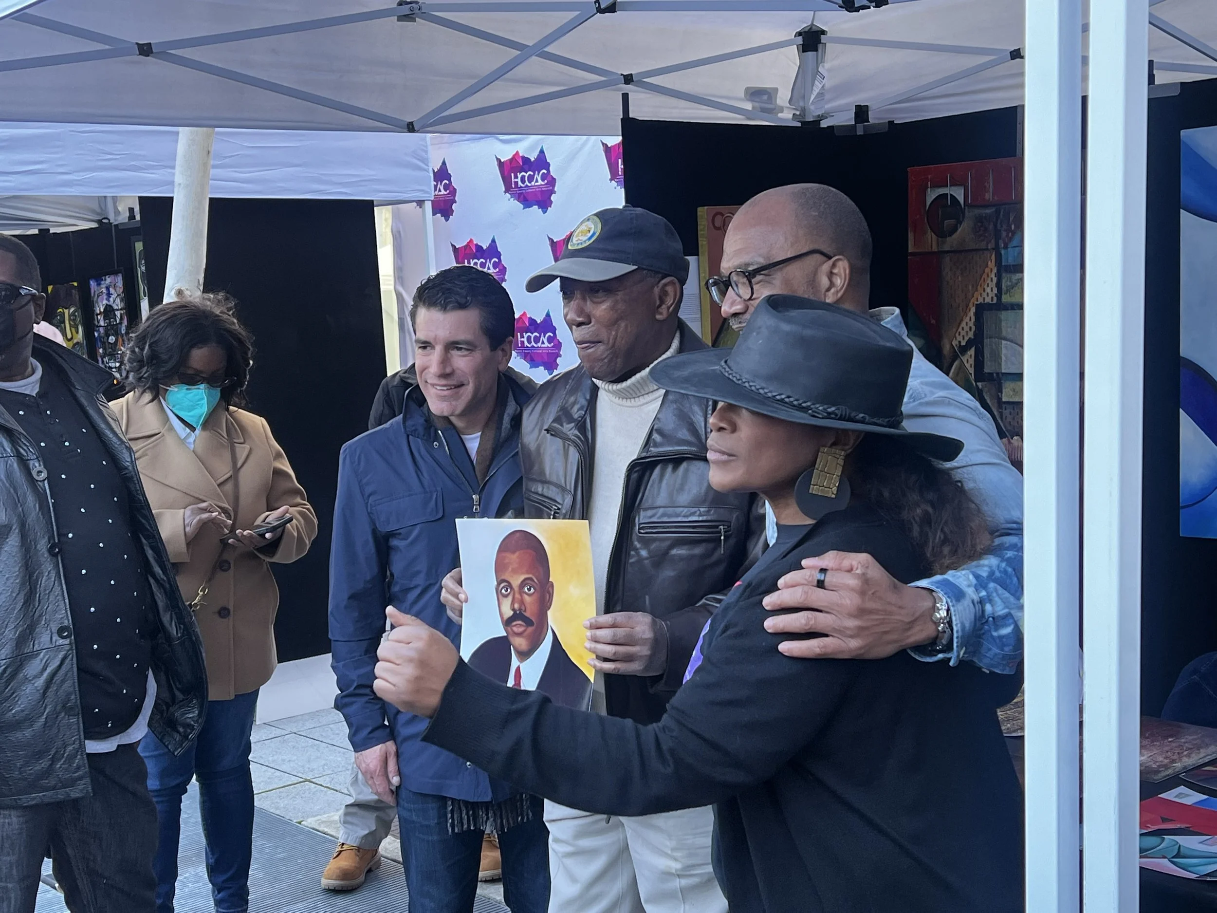 Mayor Turner takes pictures with Michelle Bonton ,her husband Ellios Bonton, and news anchor with featured art work. 