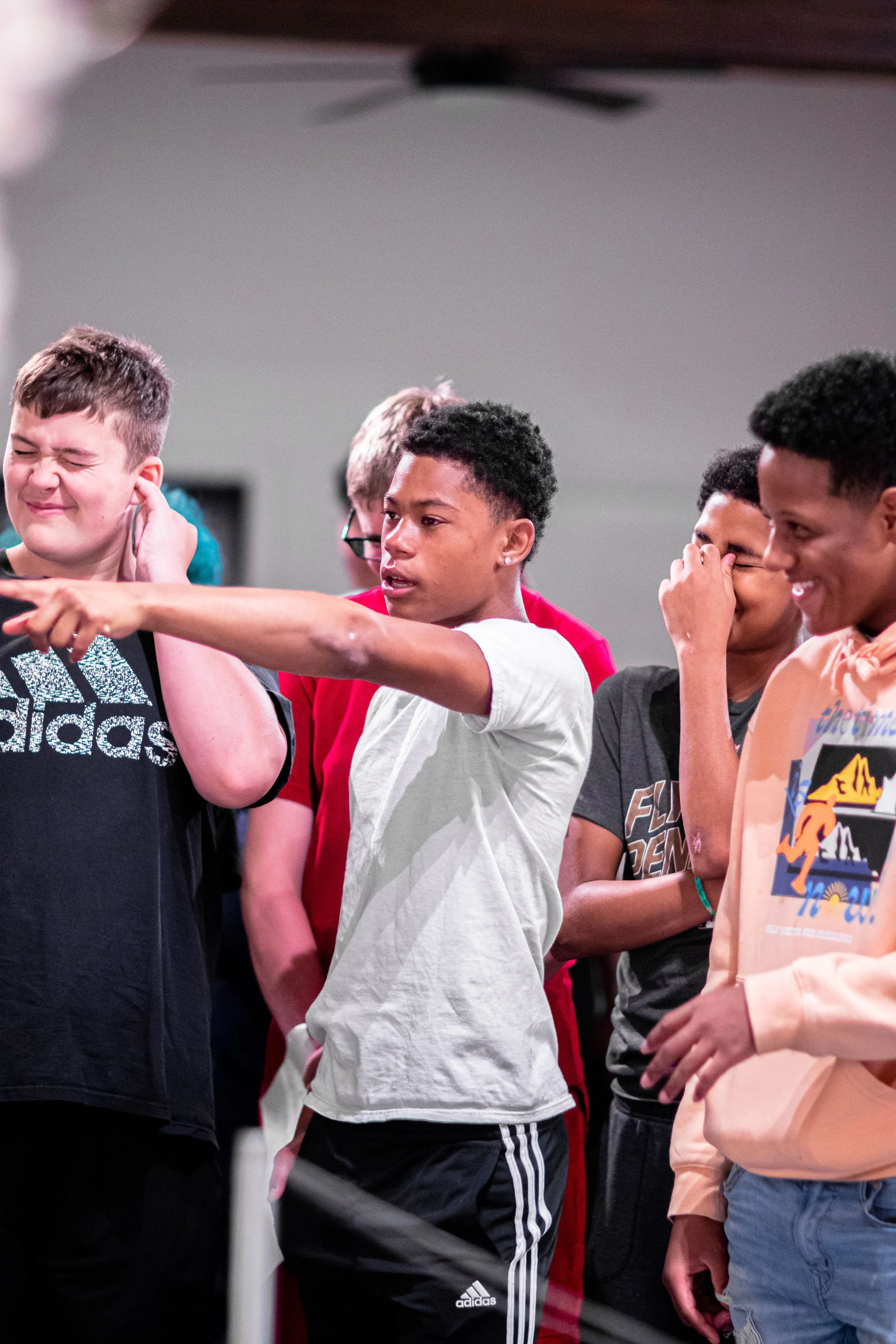 A young boy pointing toward an art piece.