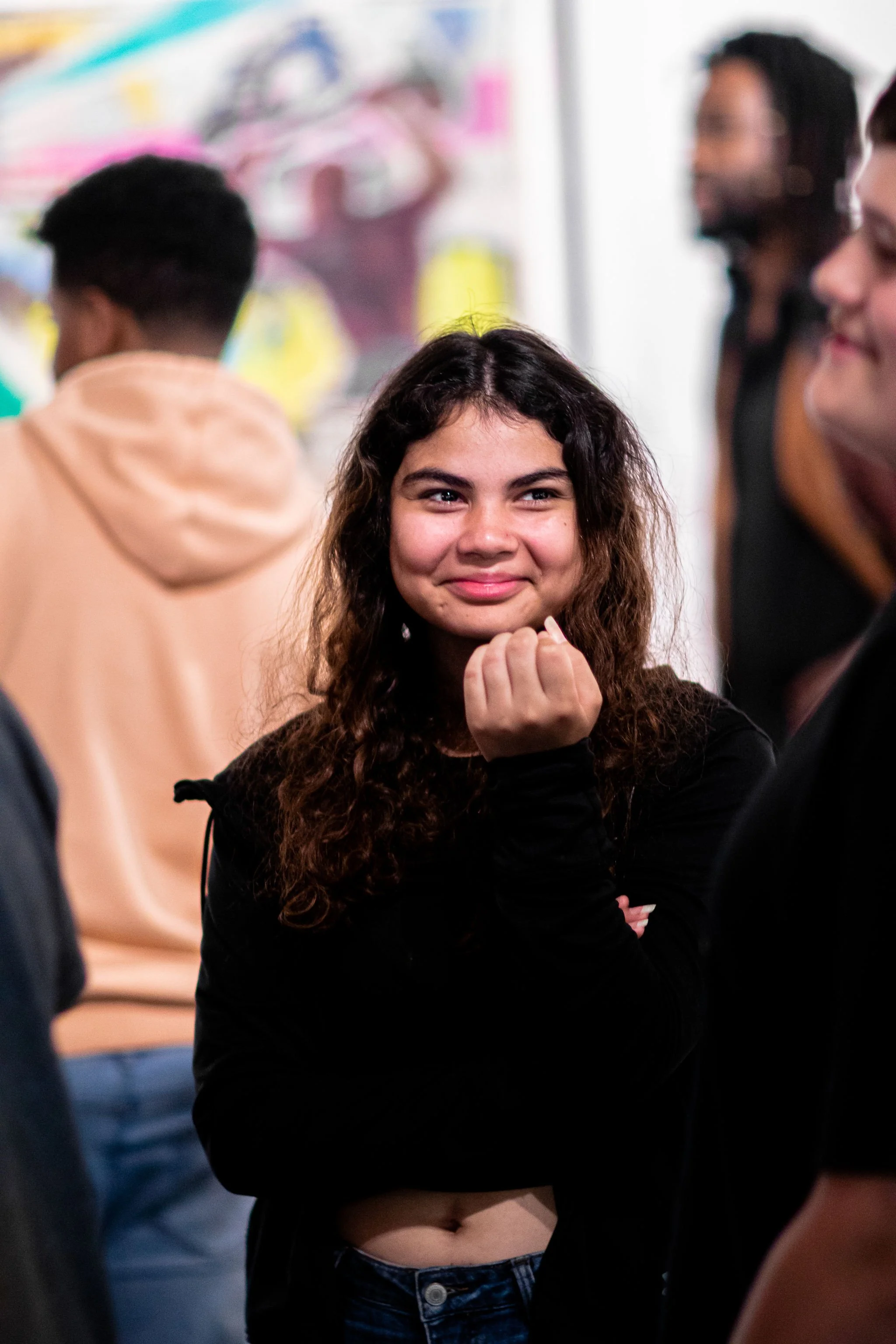 Young woman smiling at friends in the exhibit.