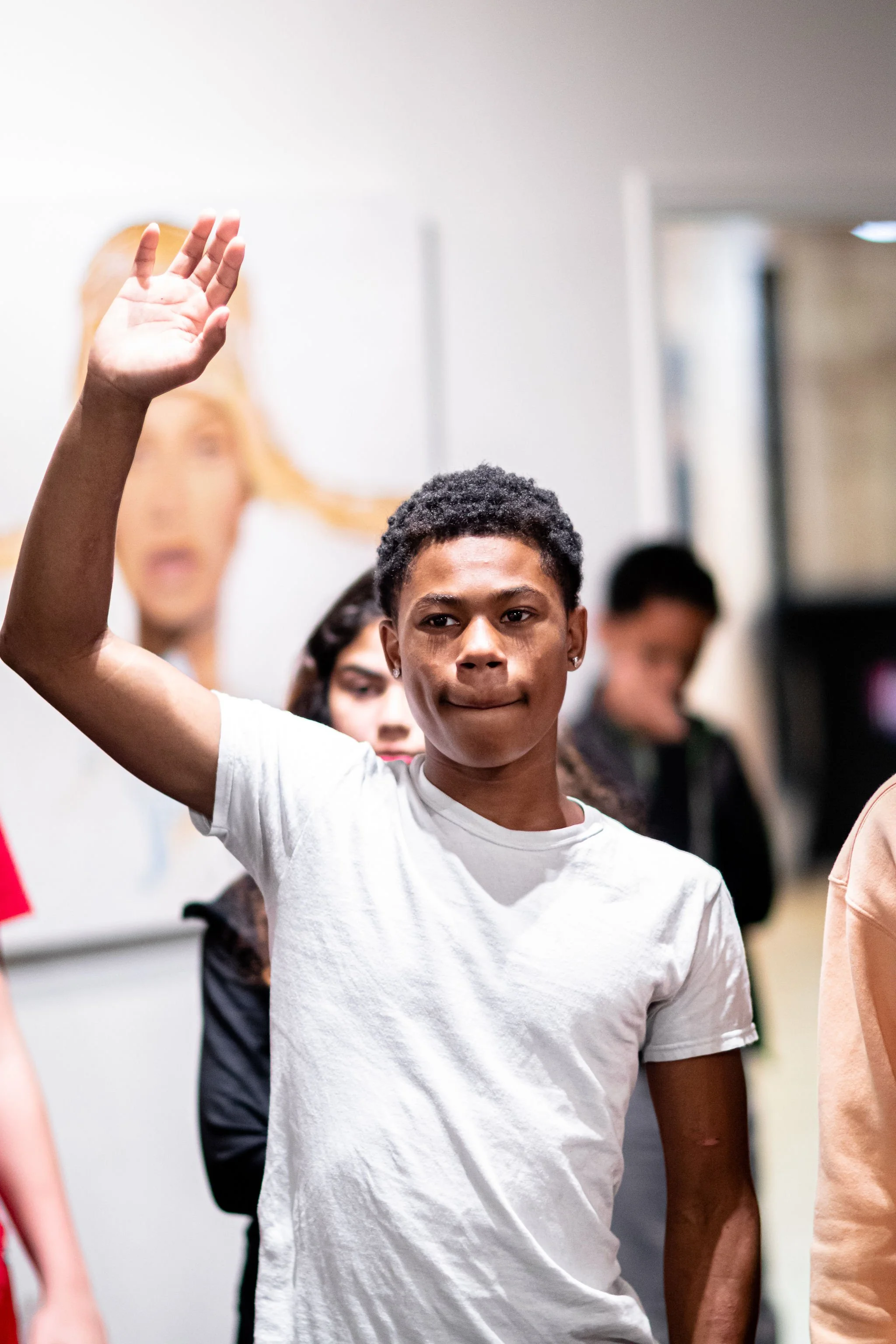 The young man raises his hand to ask questions.