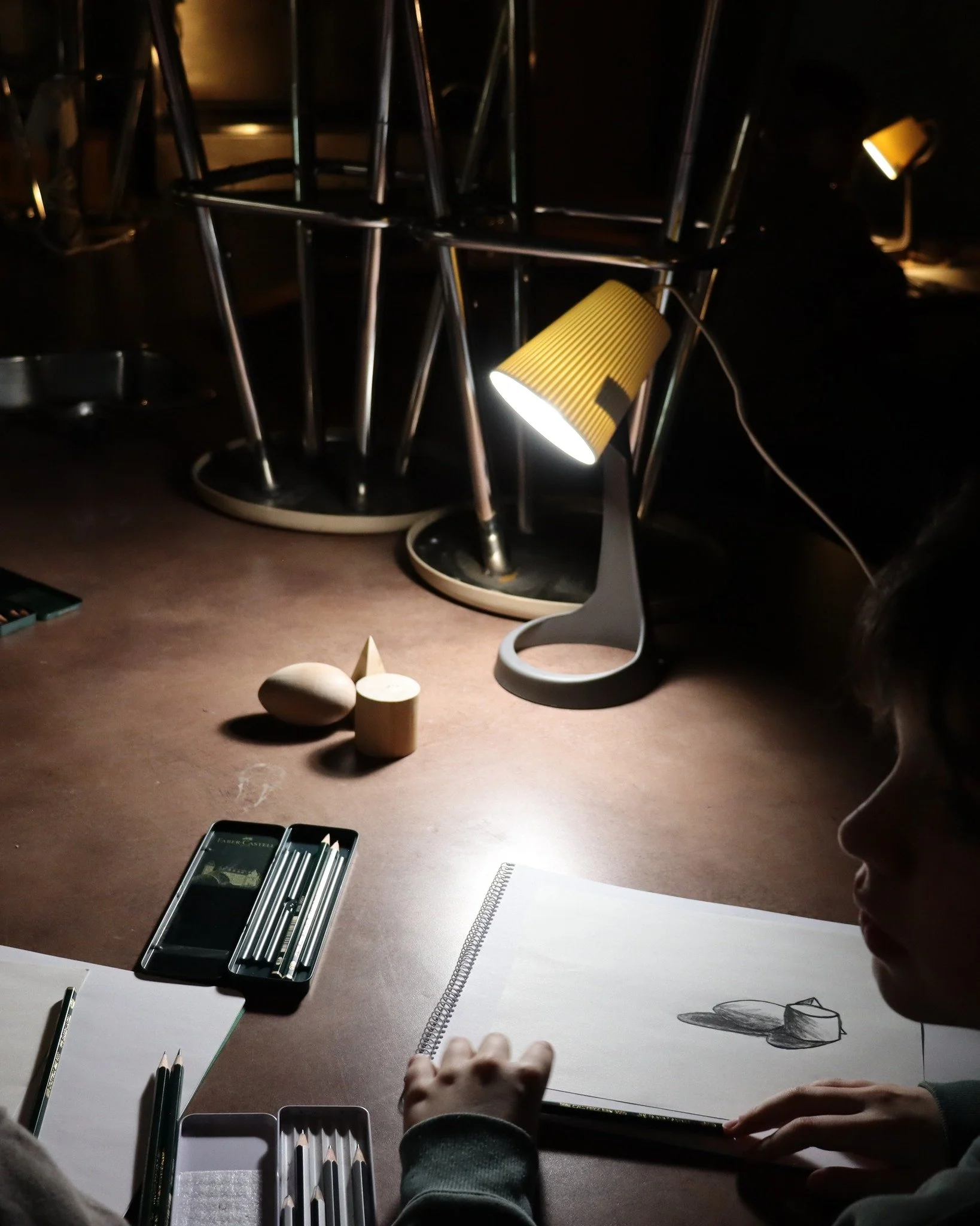 The core of the lesson is using tone (value) to transform a flat, outlined shape into a three-dimensional form. This technique encourages the student to observe the properties of light and shadow rather than relying on colour, effectively integrating