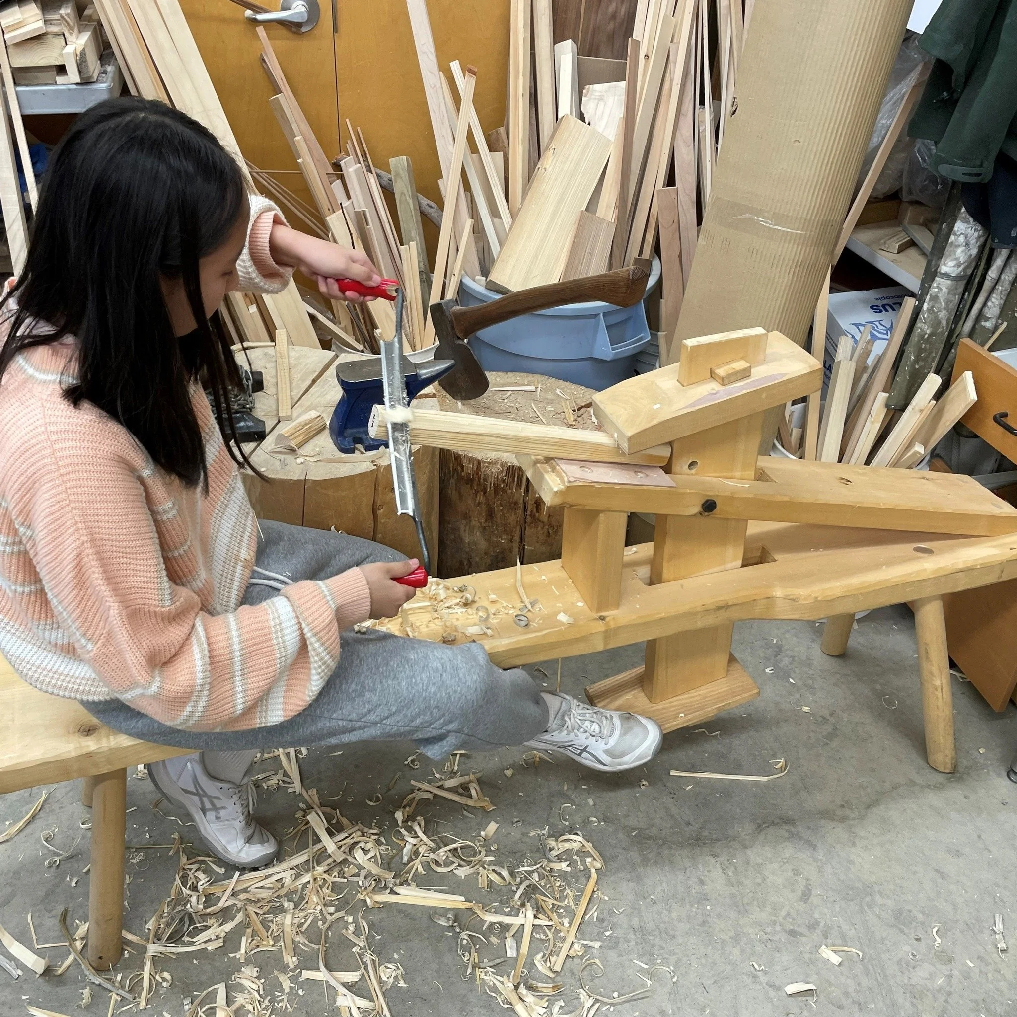 There is a focused quiet in the woodshop when students use the shaving horse to shape the legs for their three-legged stools. This stage demands incredible precision to ensure each leg is tapered uniformly. It&rsquo;s a rhythmic exercise in patience,