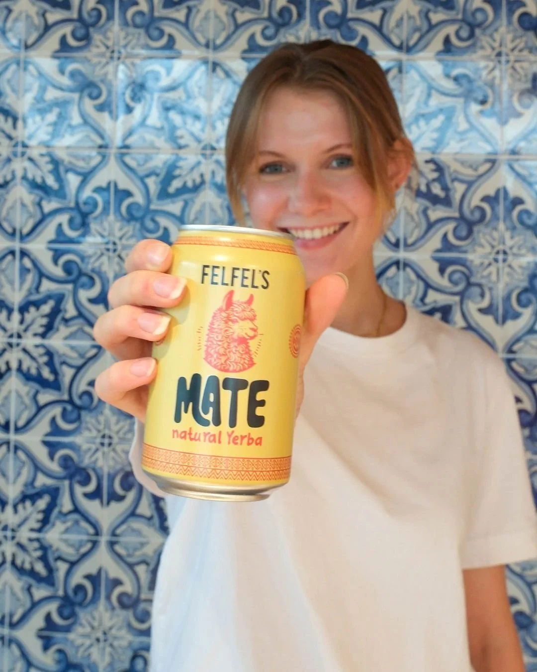 Frau hält lächelnd eine Dose FELFEL's Mate mit natürlichem Yerba in die Kamera