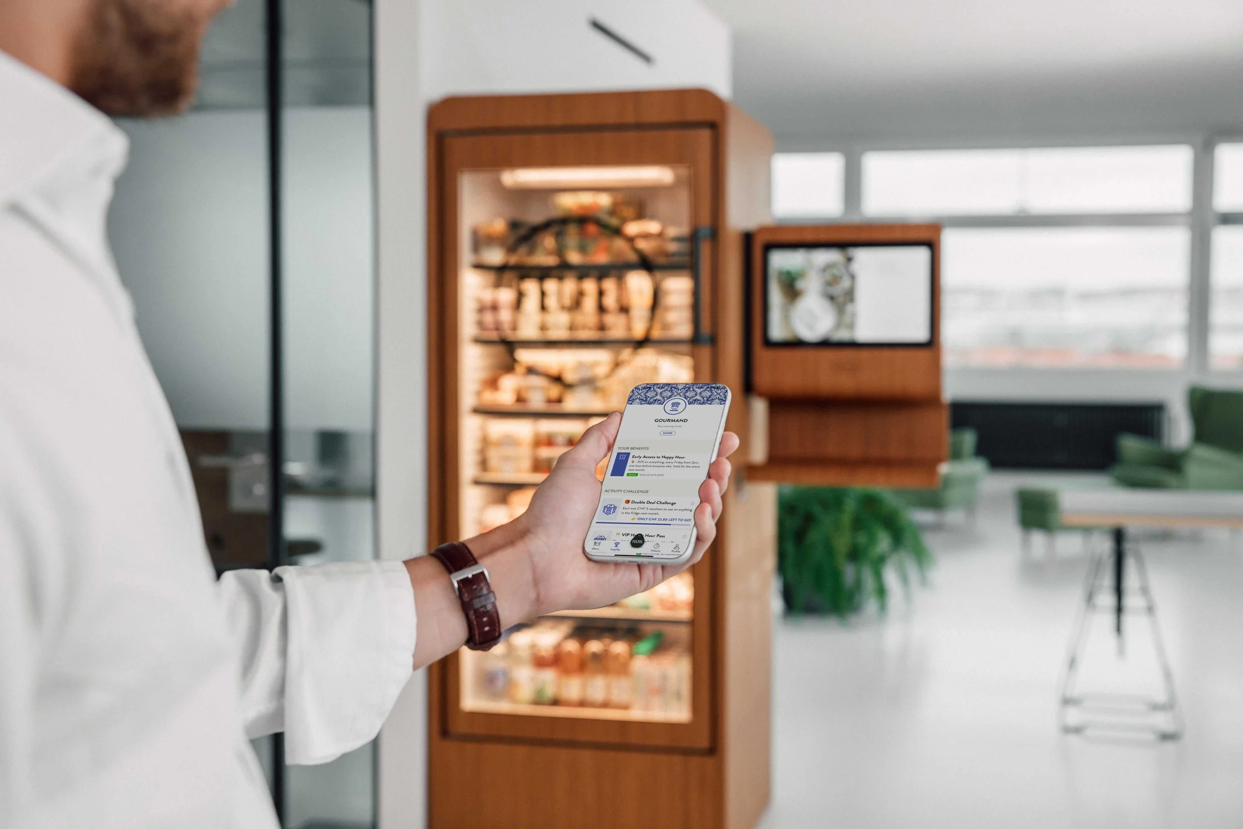 FELFEL App vor einem gefüllten FELFEL Kühlschrank im Büro.