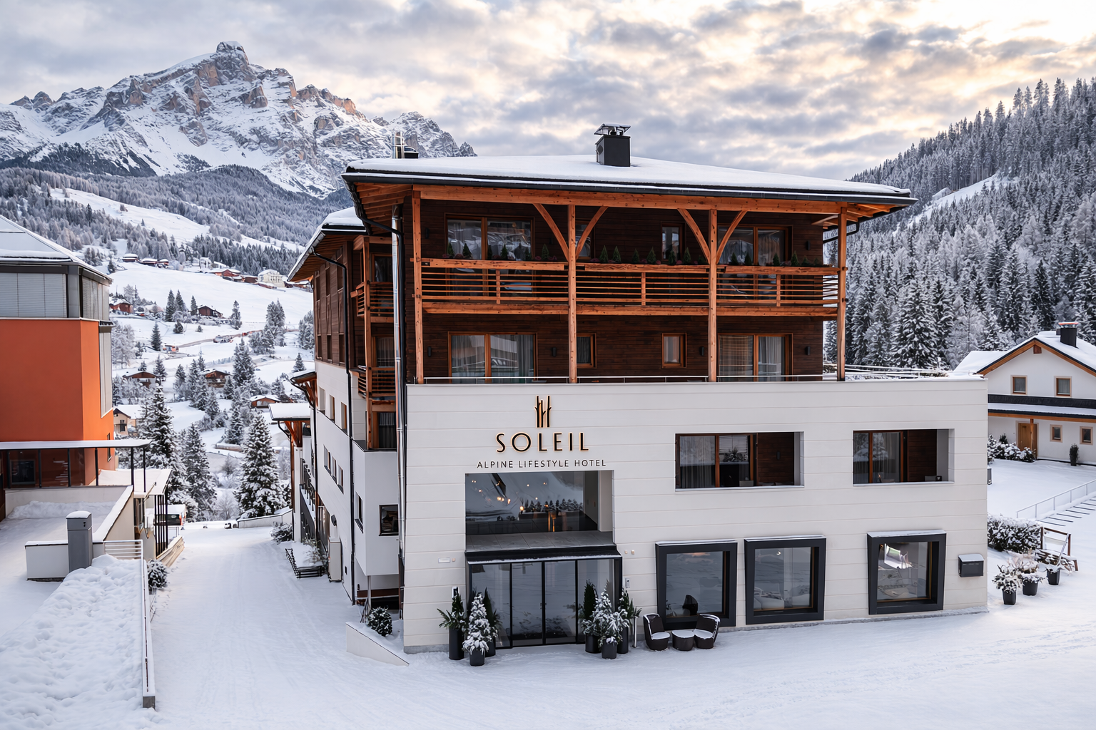 Soleil Alpine Lifestyle Hotel set against a wintry backdrop, with snowcapped fields and mountains