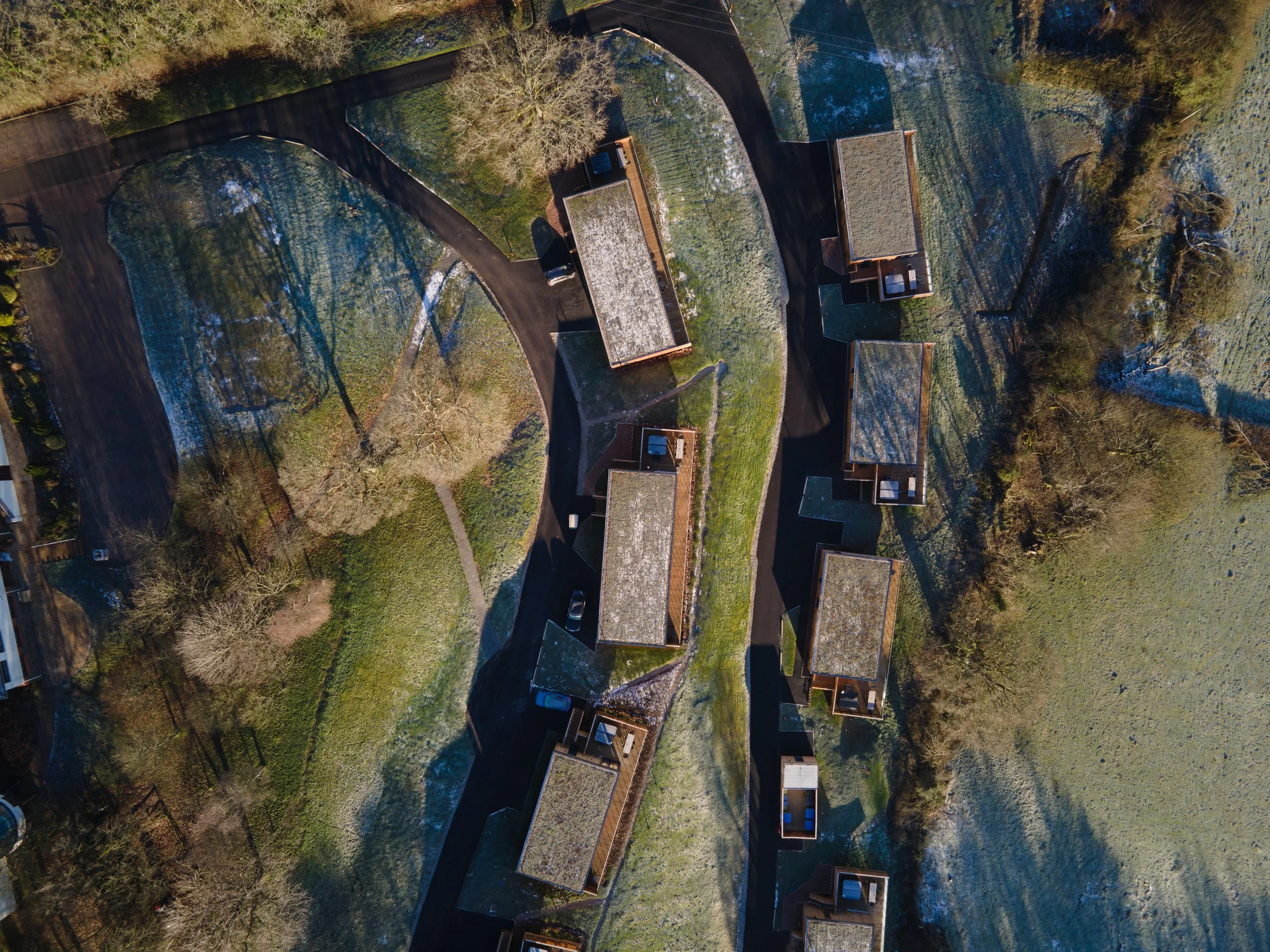 Aeriel View of The Mole Resort in Devon, UK showing lodges in first winter frost in British countryside