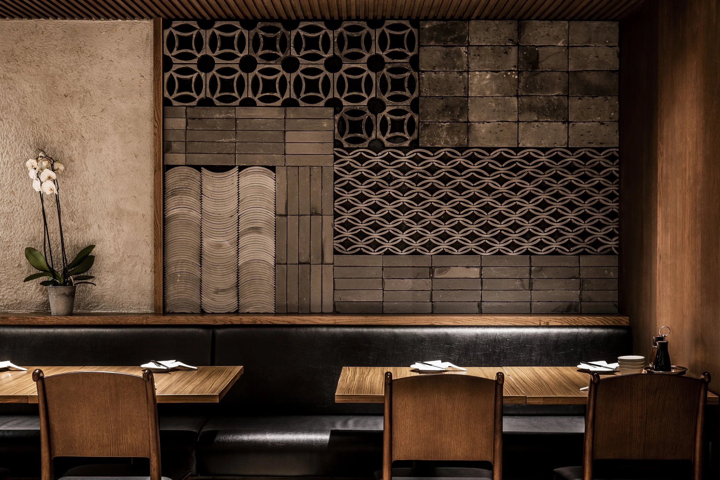 Traditional Chinese interiors in Din Tai Fung, London - Feature wall with chinese tiles and warm tones
