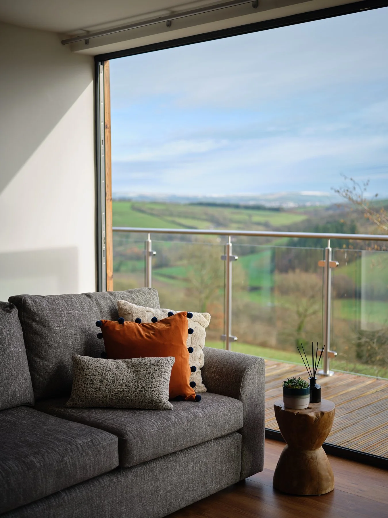 Interior of one of the lodge showing a lounge sofa with opened sliding door onto the British Countryside