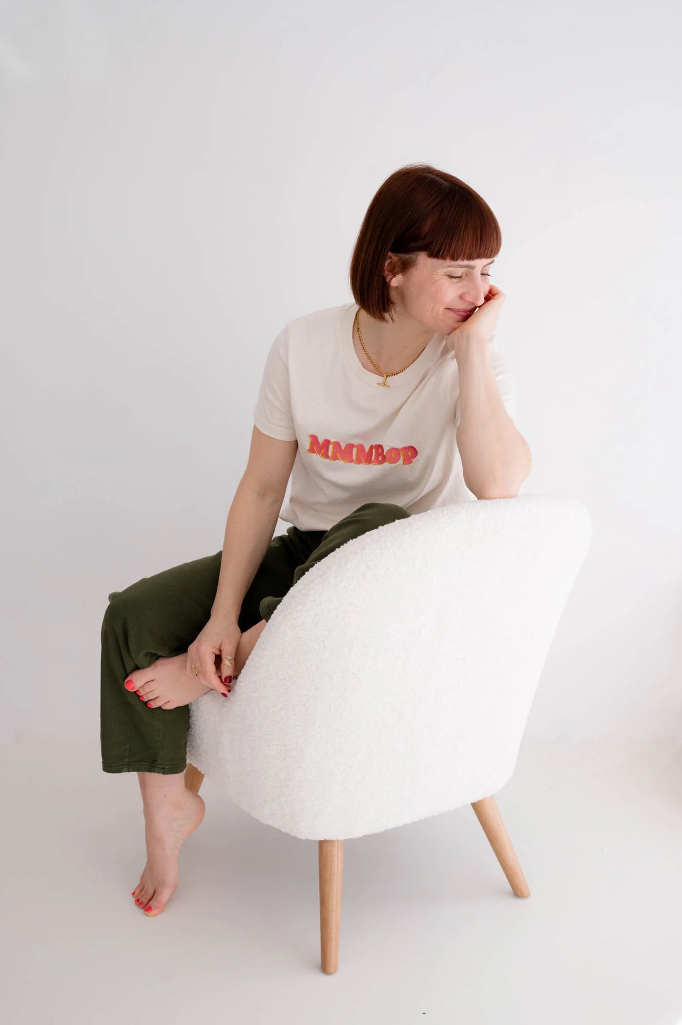 Squarespace website designer in UK resting on boucle chair