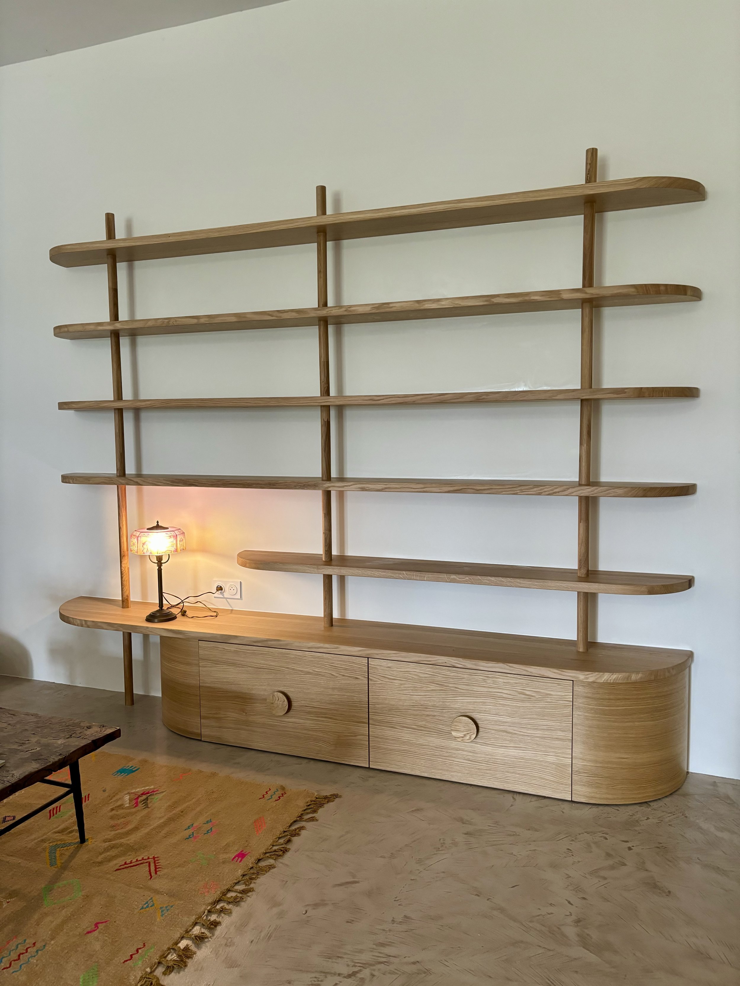 Conception et design d'un meuble sur mesure bibliothèque salon, chêne massif et finitions étagères arrondies