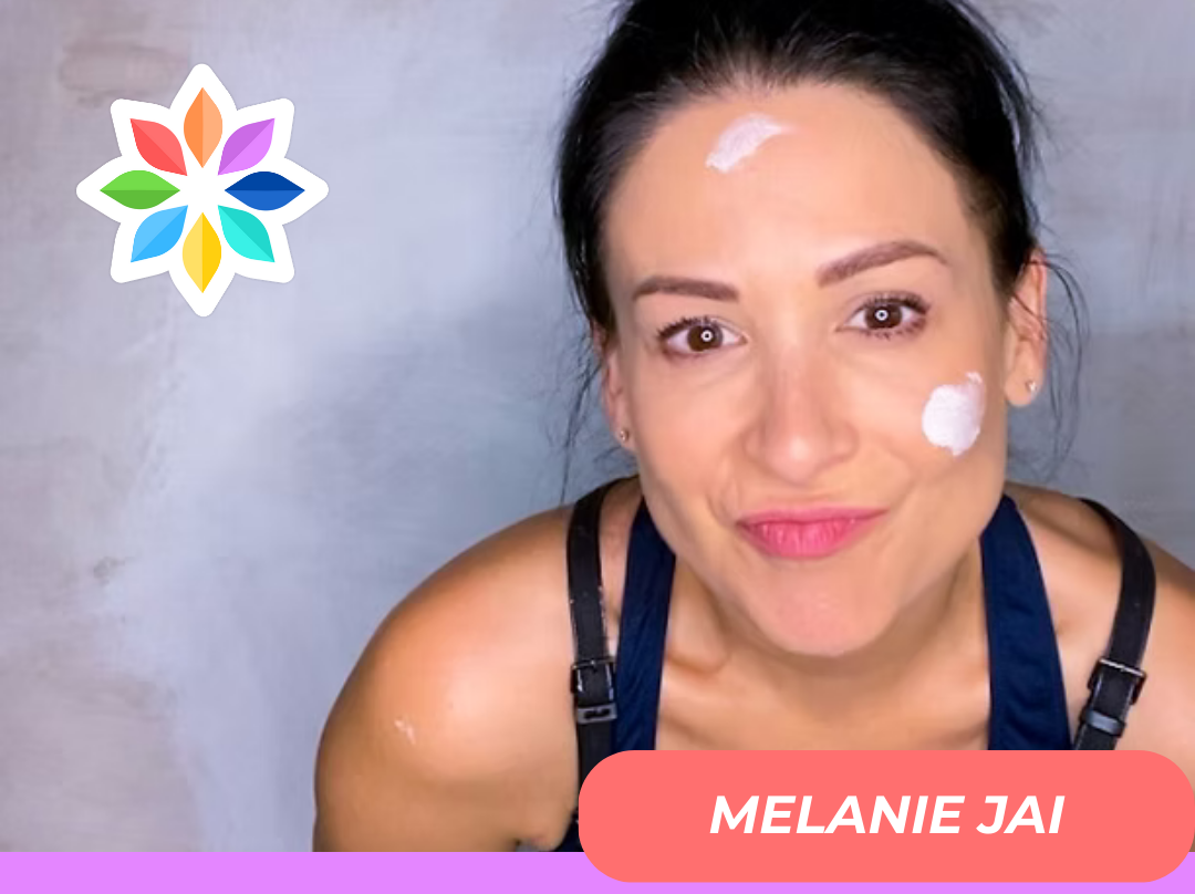 Melanie smiles at the camera. She has black hair and paint on her face. The words Melanie Jai 2025 National Survivors Day Ambassador are below. in the top left hand corner is the National Survivors Day flower petal logo.