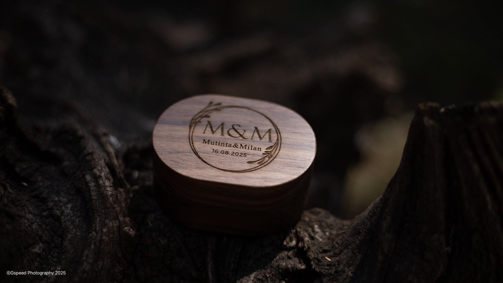 A wooden heart-shaped keepsake with engraved text and design, resting on dark textured wood.
