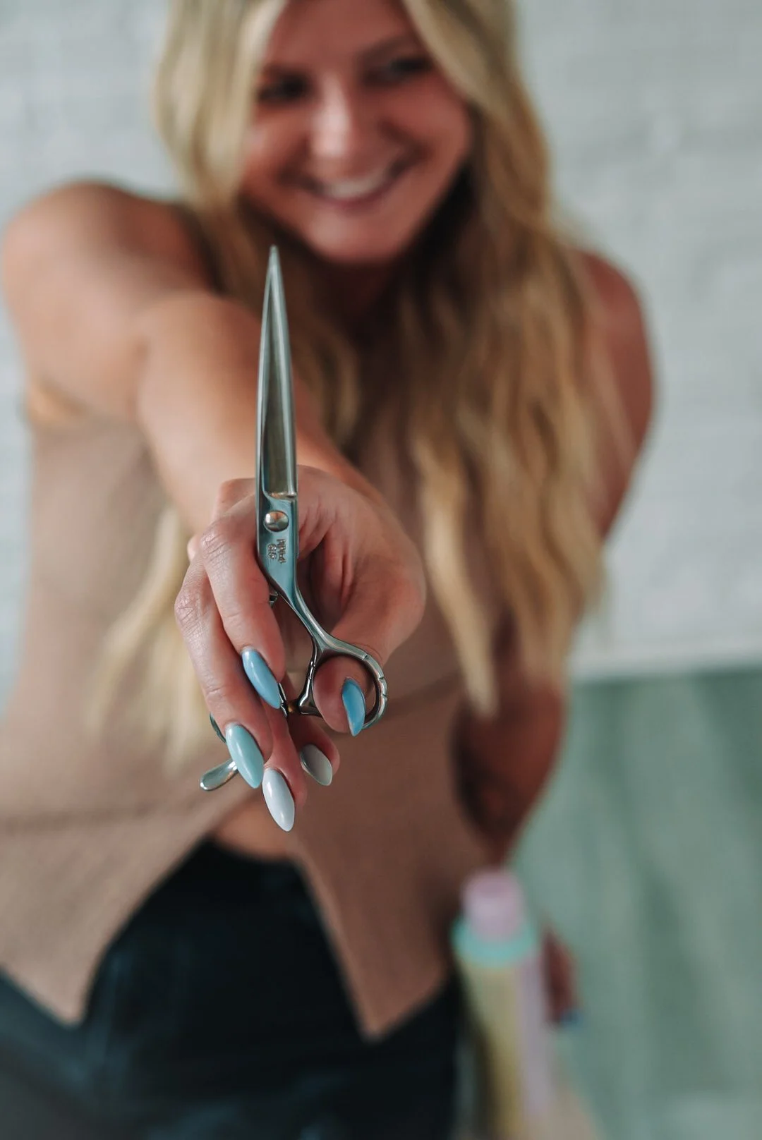 woman holding hairdresser scissors out in front her for styled brand photoshoot at The White Room in Lancaster, PA