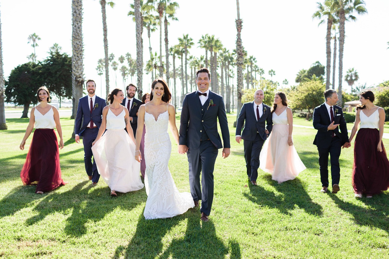 www.santabarbarawedding.com | Kaitie Brainerd | Santa Barbara Courthouse | Blush by Hayley Paige | Indochino | Revelry | Bride and Groom with the Wedding Party Among the Palm Trees