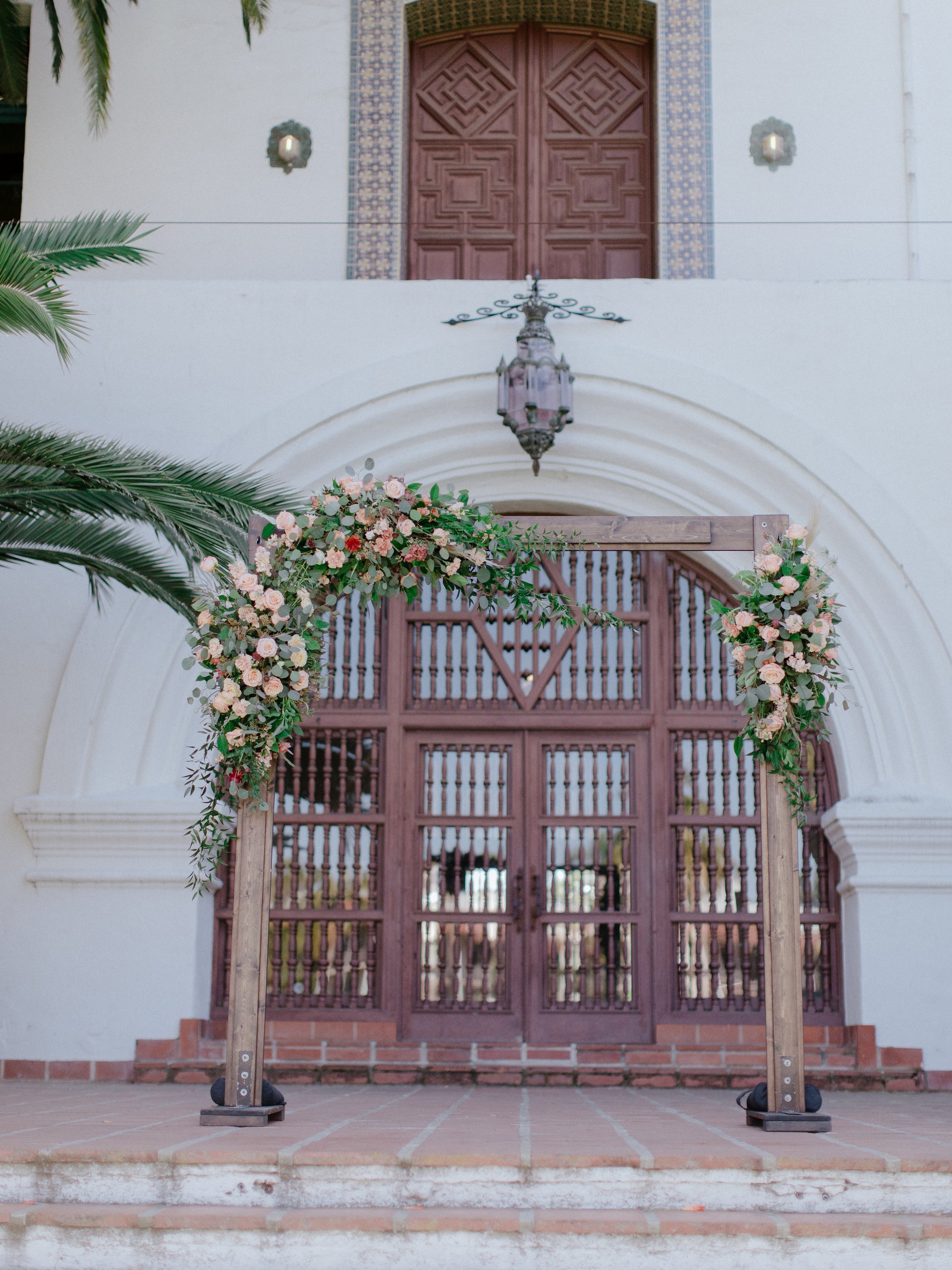 www.santabarbarawedding.com | Chris J. Evans | Santa Barbara Courthouse | Wedding Arch with Blush Florals and Greenery on the Steps of the Courthouse