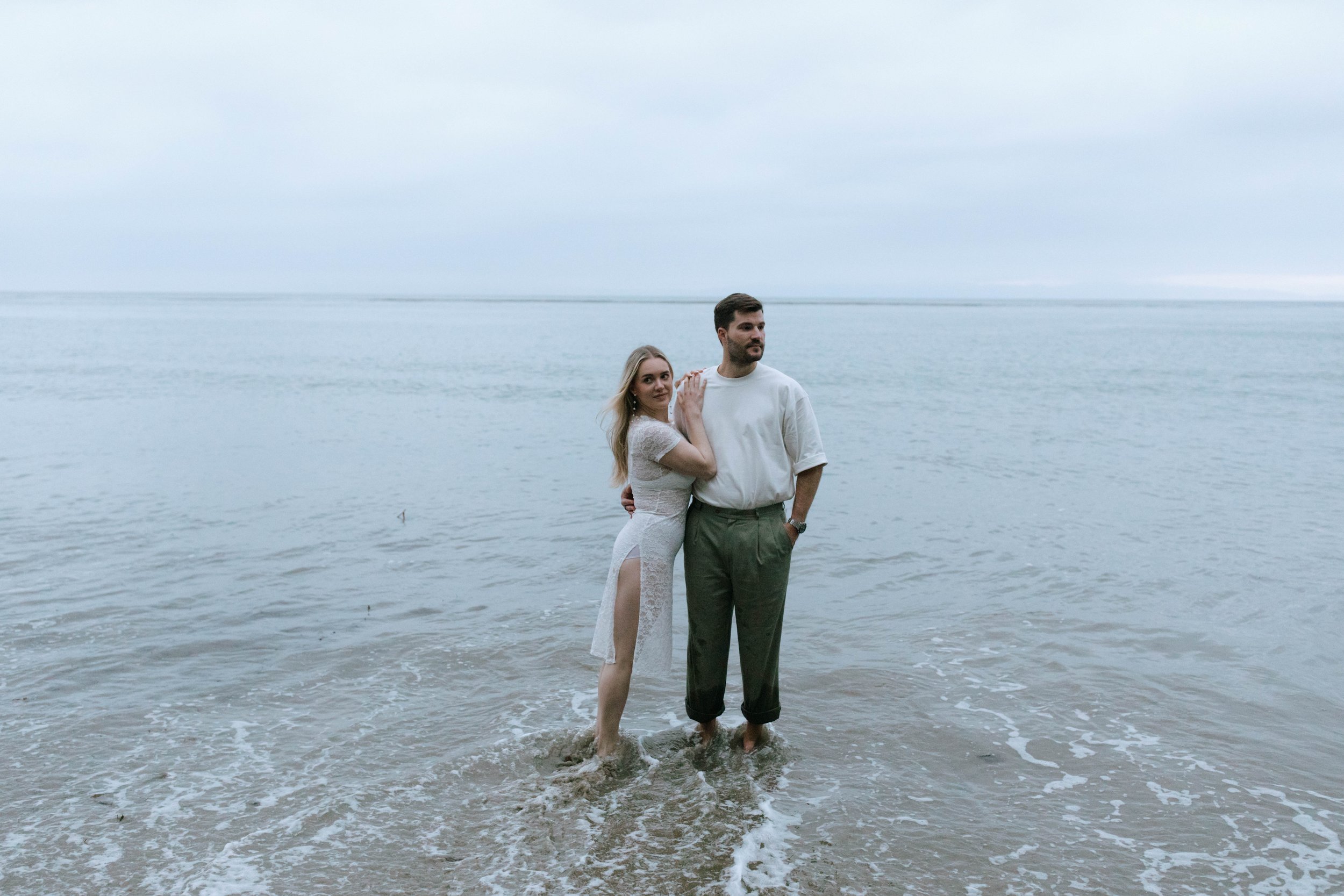  www.santabarbarawedding.com | Monique Bianca Photography | Santa Barbara Beach | Rotate | Engaged Couple Posing with Their Feet in the Water at the Beach