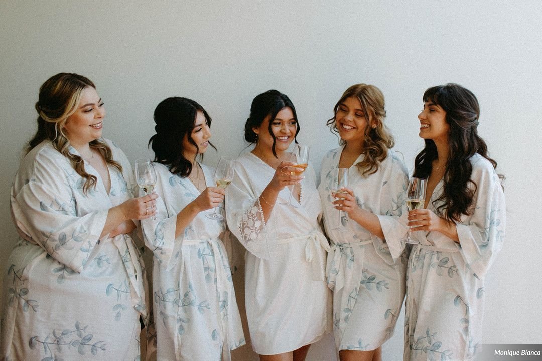 www.santabarbarawedding.com | Our Lady of Mount Carmel | Monique Bianca | White Sage | Intrepid Floral Co. | Bride Having Champagne with Bridesmaids in Robes