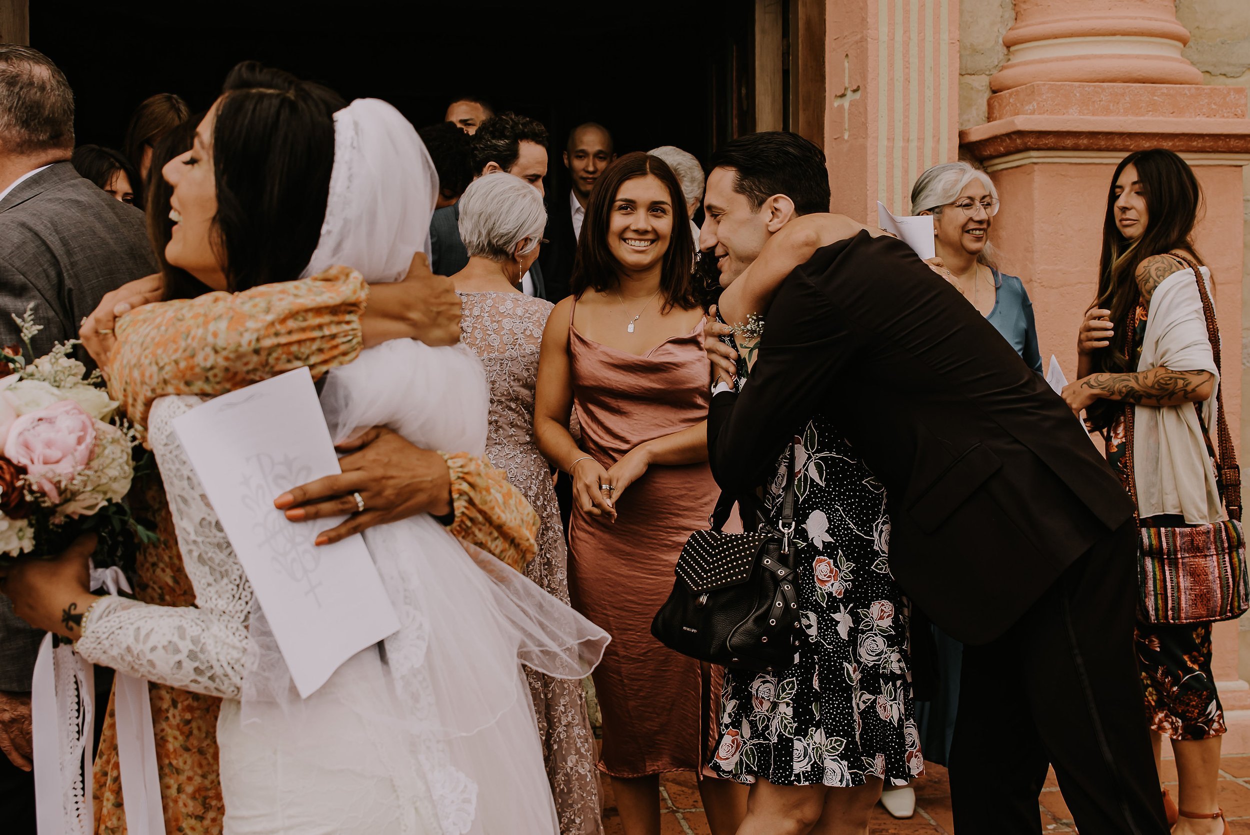 www.santabarbarawedding.com | Staci Hood | Old Mission SB | Flowers for Love | Kelly Novobielski | Emily Lynn and Company | Grace Loves Lace | Calvin Klein | Couple Hugging Guests