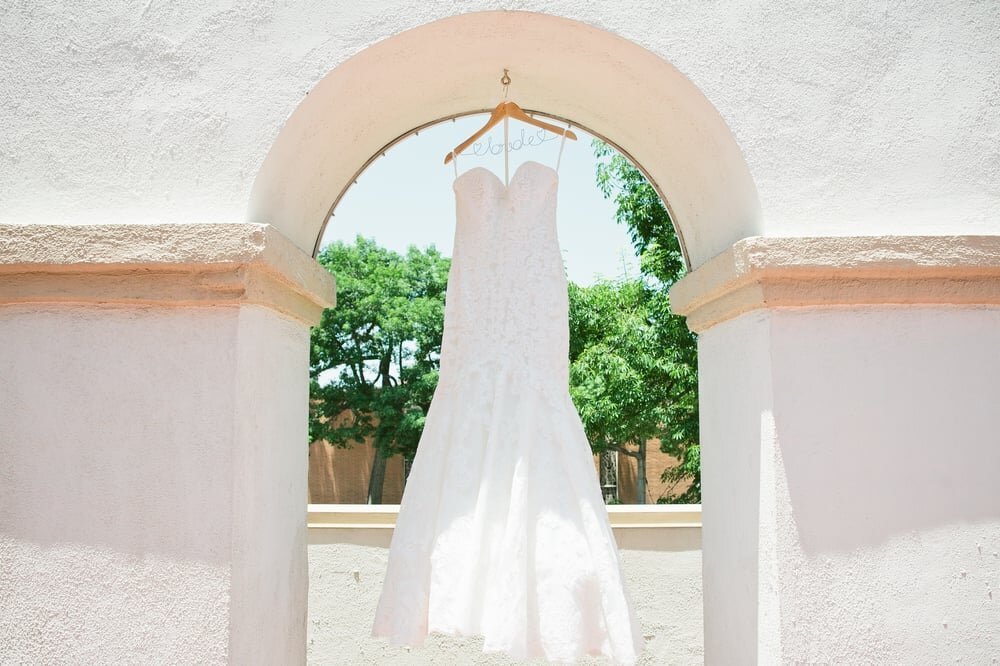 www.santabarbarawedding.com | Ana Maria’s Bridal Boutique | Ryan Vermilion Photography | Mermaid Style Wedding Gown Hanging from the Building Arch