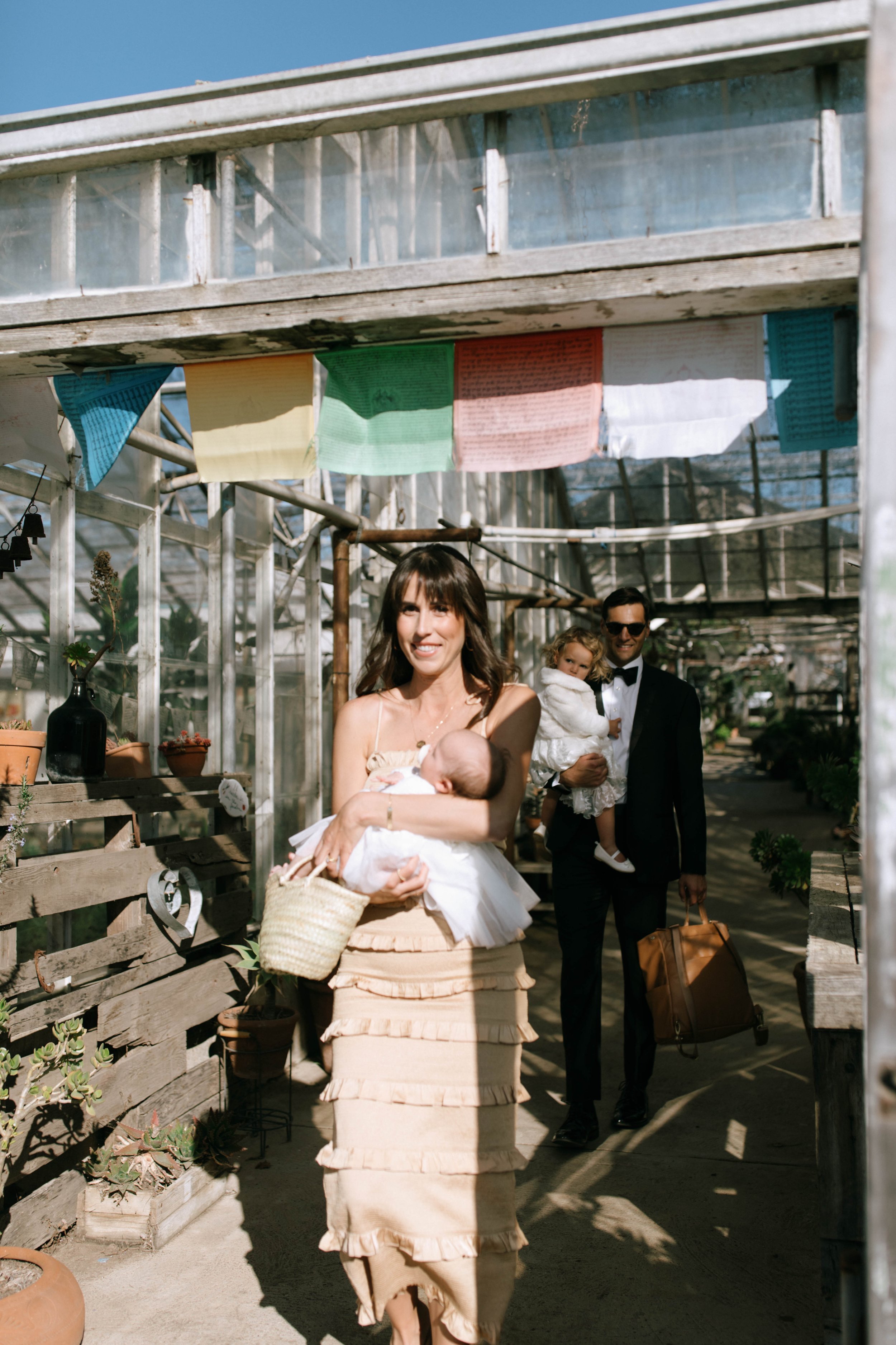 www.santabarbarawedding.com | Monique Biance | Amazing Days Events | Dos Pueblos Orchid Farm | Studio Fleurish | Guest Carrying Her Baby Through the Greenhouse