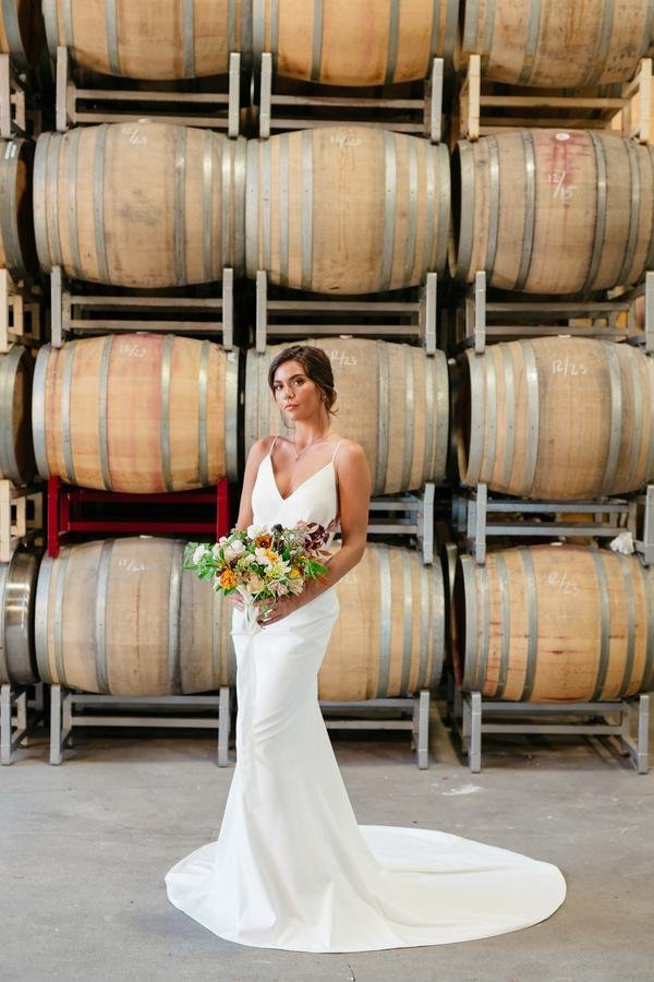 www.santabarbarawedding.com | Roblar Winery | Lerina Winter | Boheme Events | Intrepid Floral Co. | Lovely Bride | Dreamcatcher Artistry | Bride with Bouquet in Front of Wine Barrels