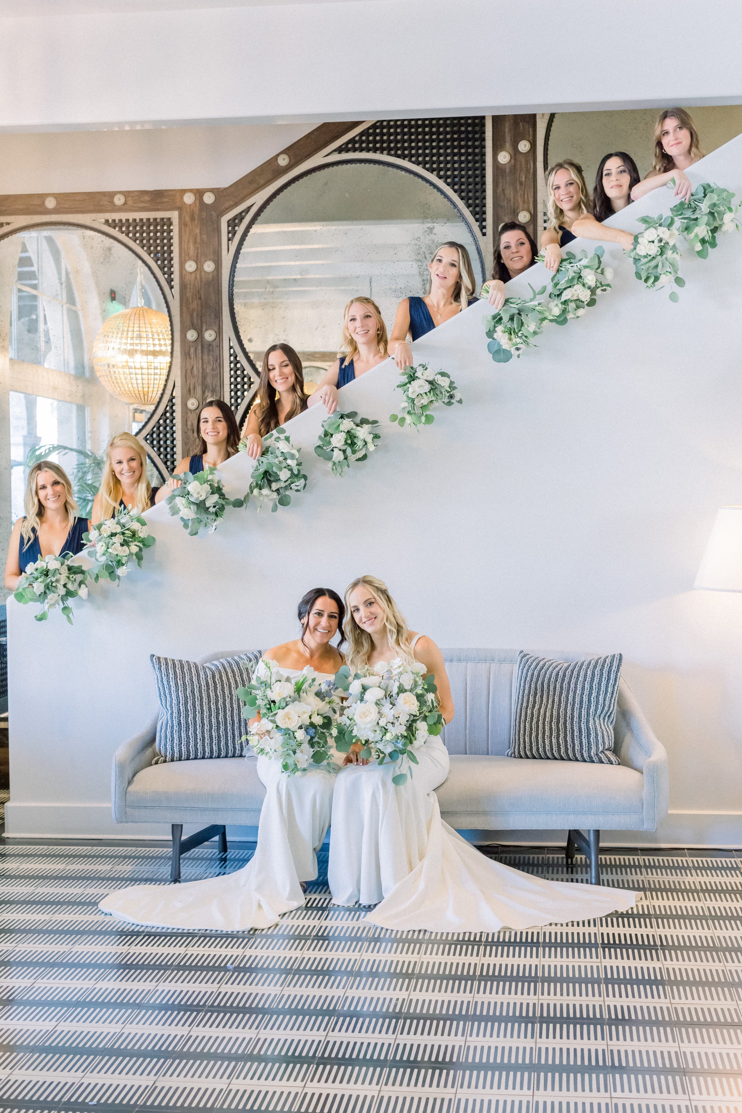 www.santabarbarawedding.com | James &amp; Jess | MOXI | Ann Johnson Events | Brides Posing With Their Bouquets and Bridesmaids Lined Up on the Stairs Behind