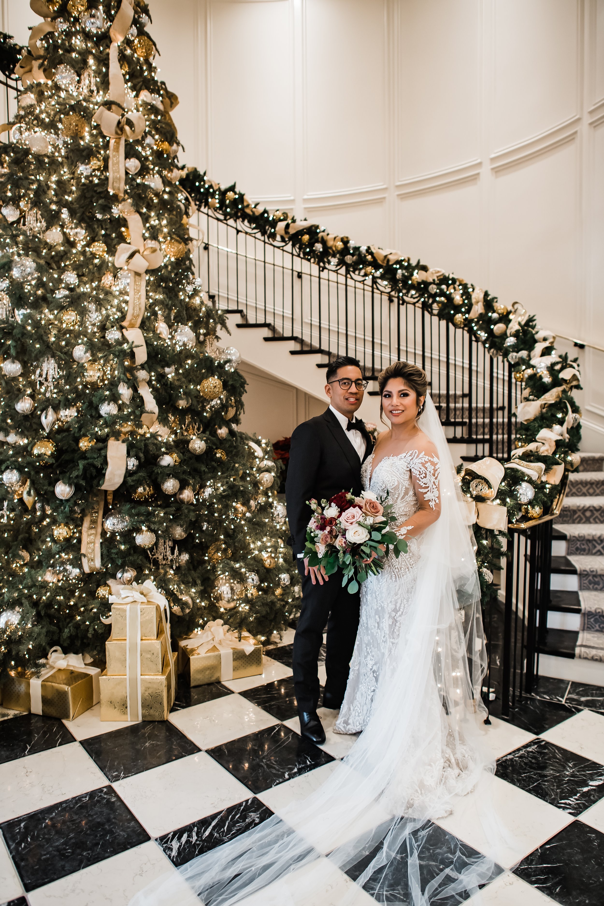 www.santabarbarawedding.com | Rosewood Miramar | Events by Maxi | Michelle Ramirez | Tangled Lotus | Bride and Groom Pose by a Christmas Tree Inside the Venue